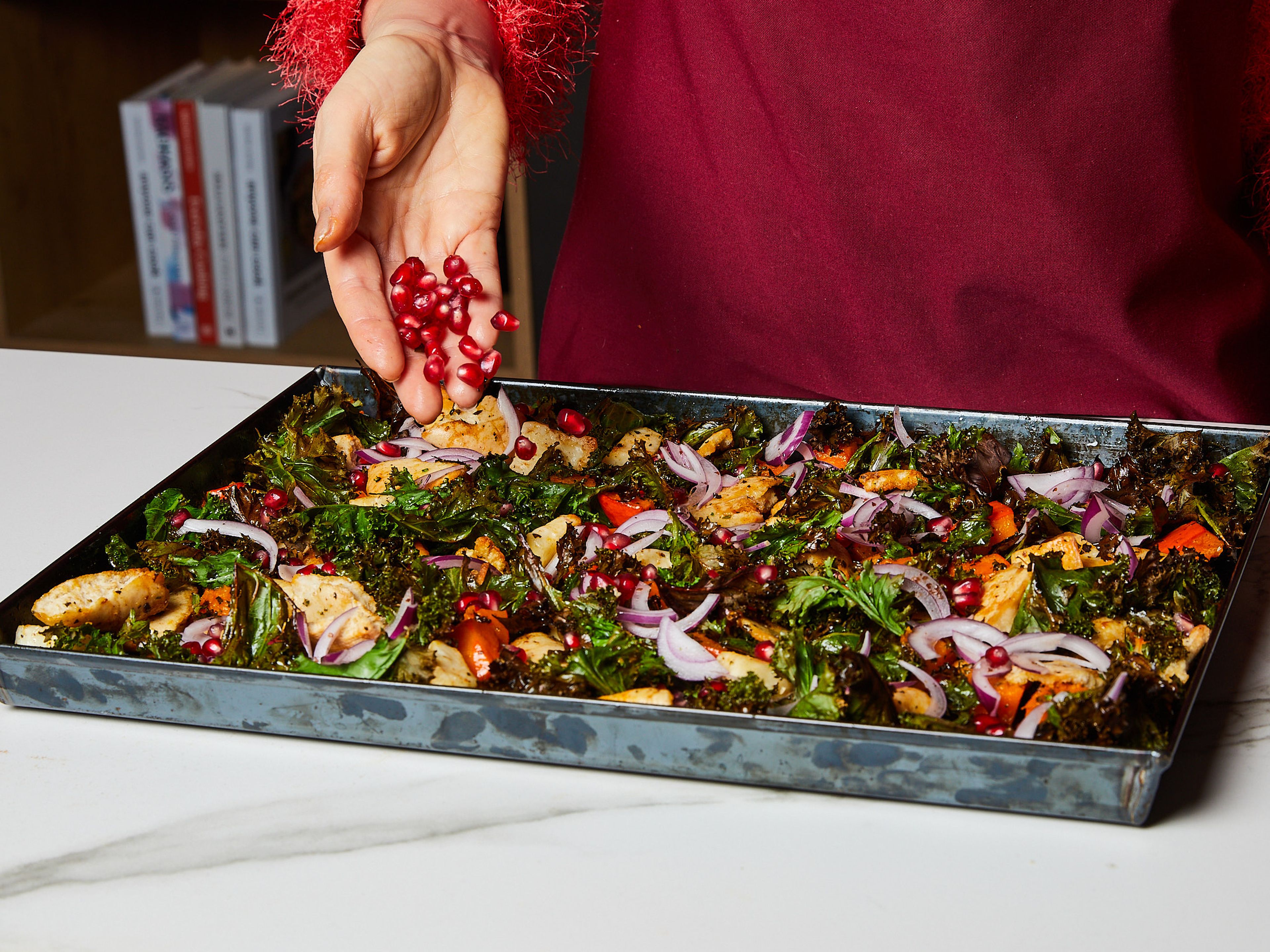 Nach dem Rösten das Blech aus dem Ofen nehmen, mit dem Dressing beträufeln und vorsichtig vermengen. Zum Schluss die marinierten Zwiebeln abgießen und über den Salat geben, mit Granatapfelkernen bestreuen und noch lauwarm servieren.