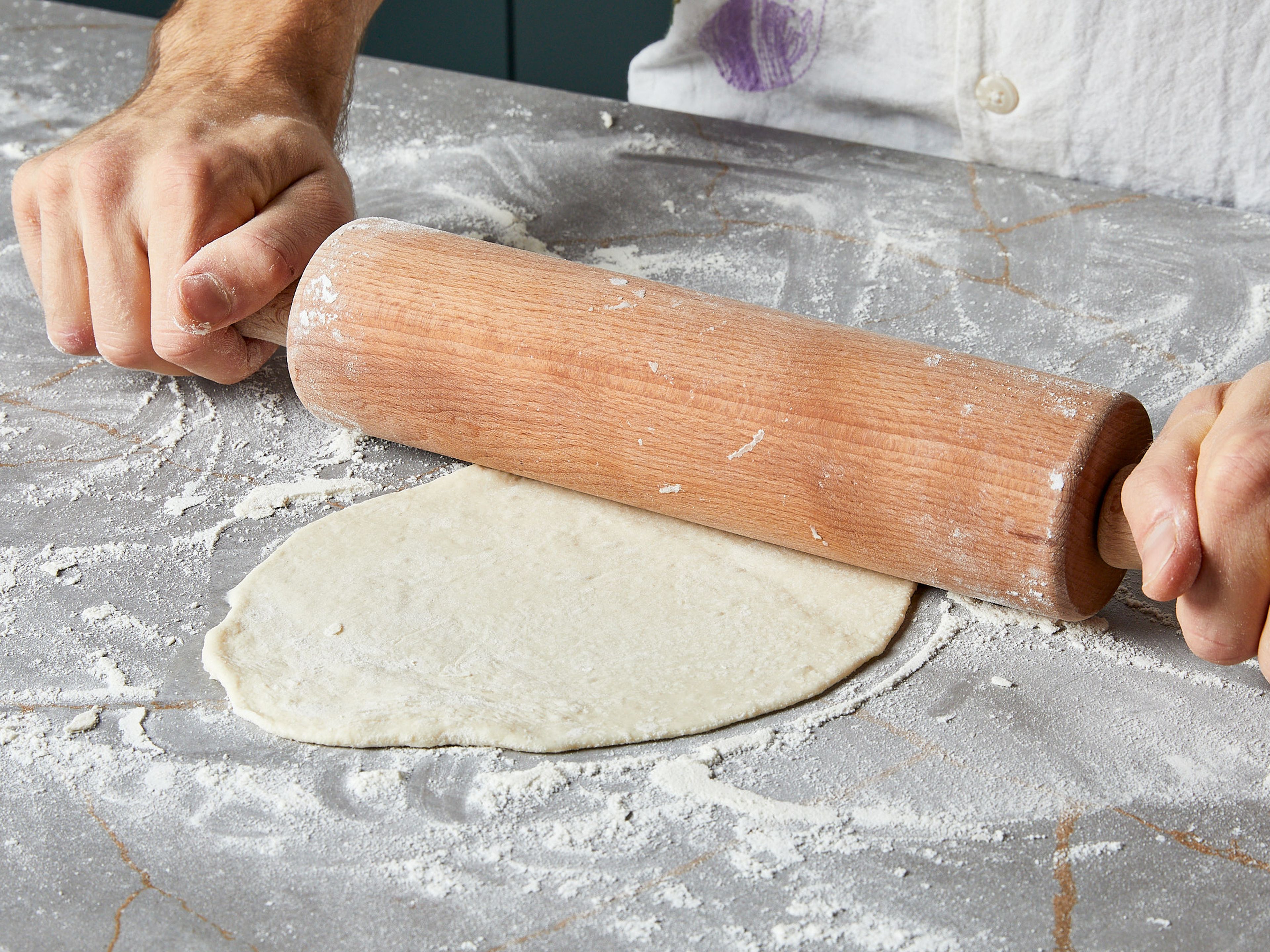 Preheat the oven to 200°C/390°F. Once the dough is ready, transfer to a floured work surface. Sprinkle more flour on top and divide the dough into 4 equal parts. Dust the surface for each piece and roll them out with a rolling pin into very thin (0,2 cm) pancake-shaped pieces. Lay them out on a baking sheet lined with parchment paper.