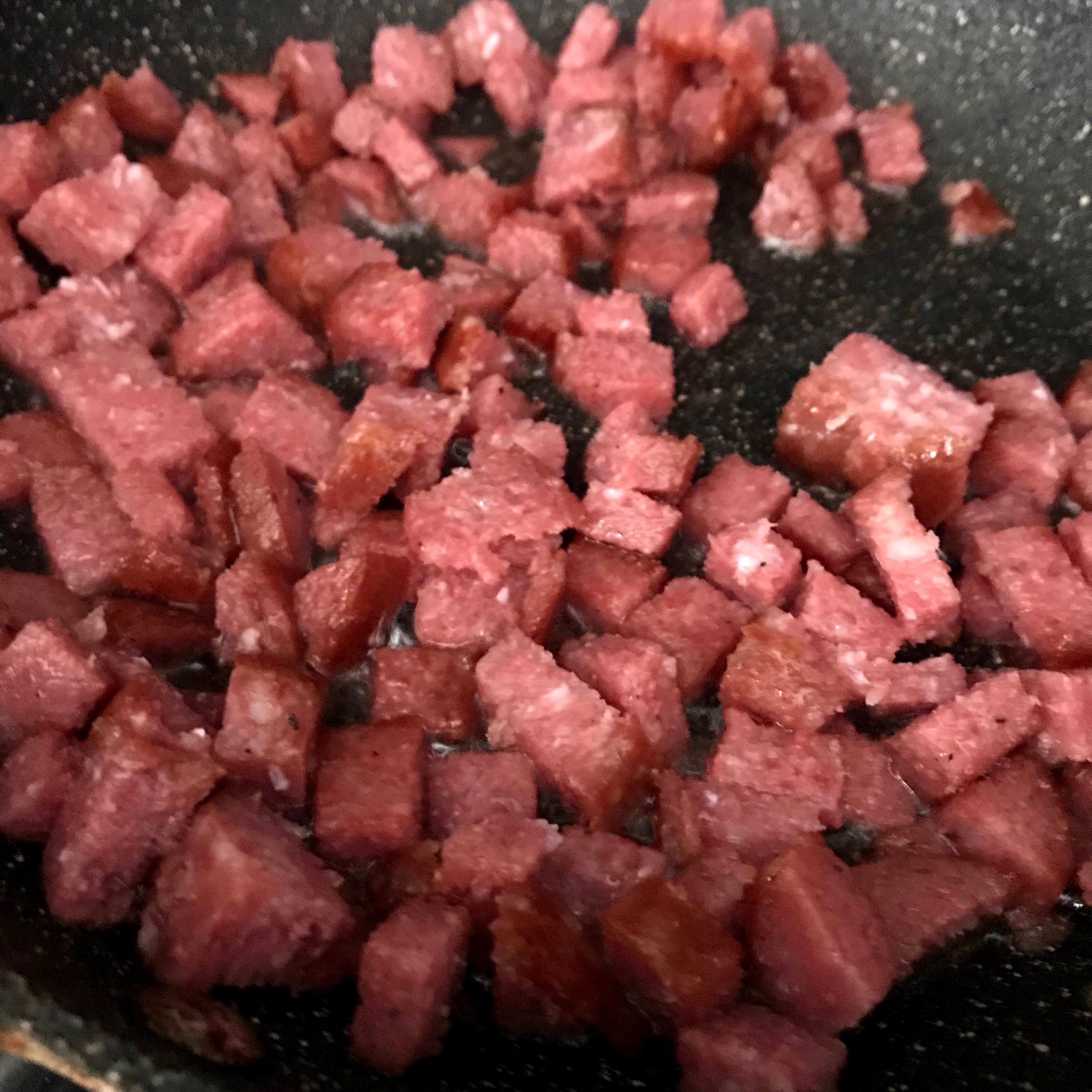 Fry the salami until crispy and drain on a paper towel until cool. Crumble into small bits,then place them into a large bowl.