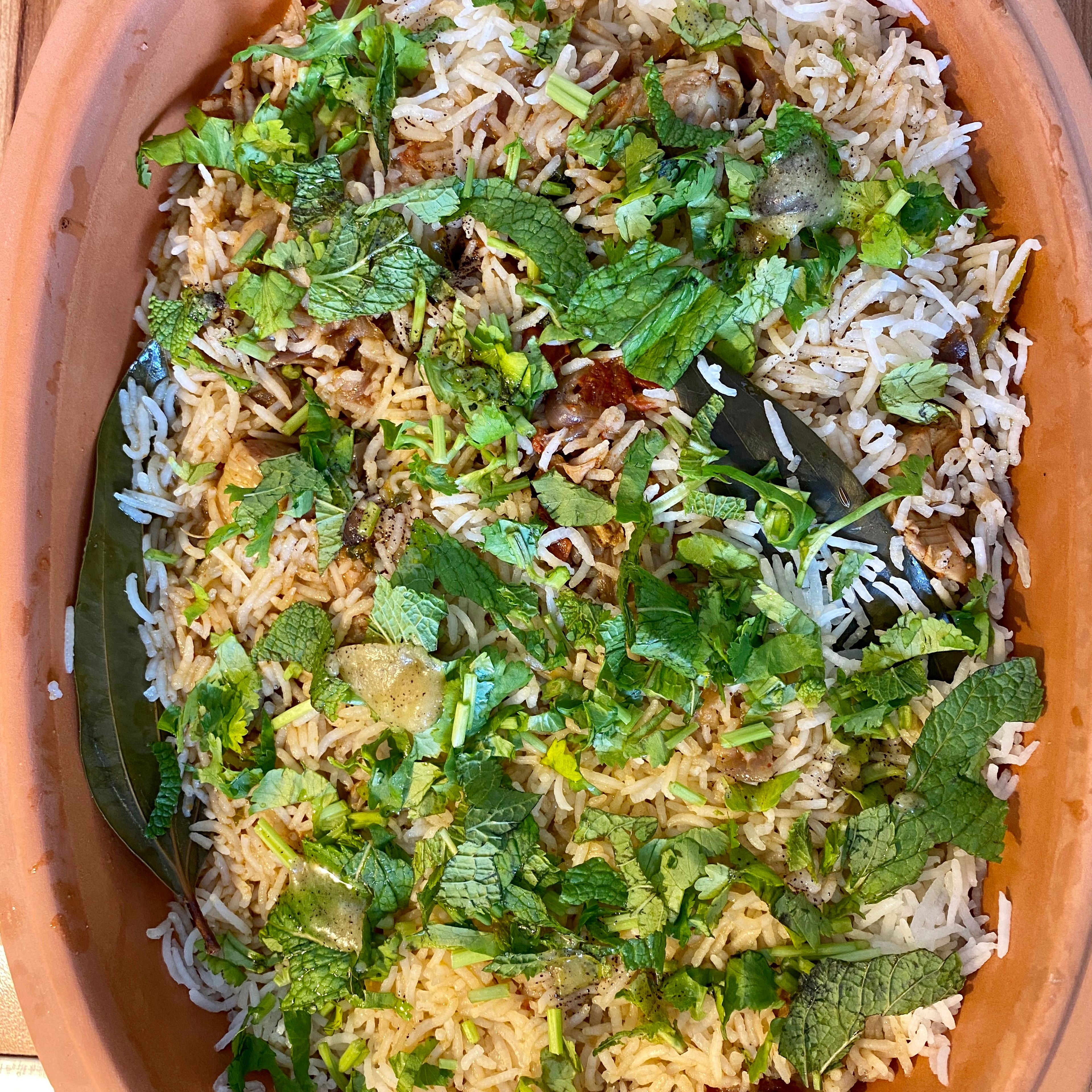 Making the biryani!! - Almost there! Add the curry base to a large empty casserole.  To this, add the rice on top and garnish with coriander and mint leaves. Layer the top with the ghee , rose water and jasmine water. Place the pot in the oven for 25 mins at 225 and 12 mins in 200. Take out the casserole and leave it aside for 10 minutes. There you go! The biryani is ready to be served. Have a feast! 