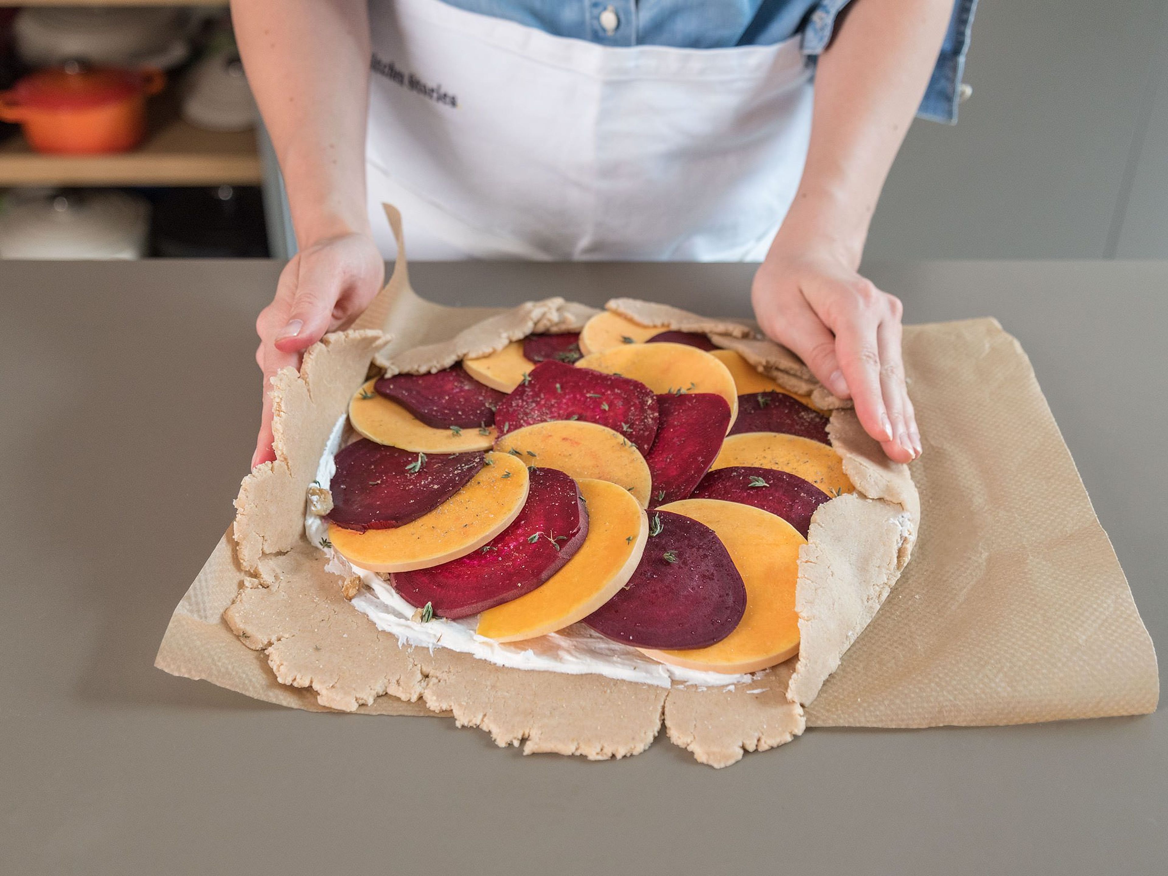 Pluck thyme leaves from stems and sprinkle half over the dough. Assemble the squash and beetroot slices over the goat cheese and sprinkle remaining thyme and salt and pepper over everything. Carefully fold over edges of dough.