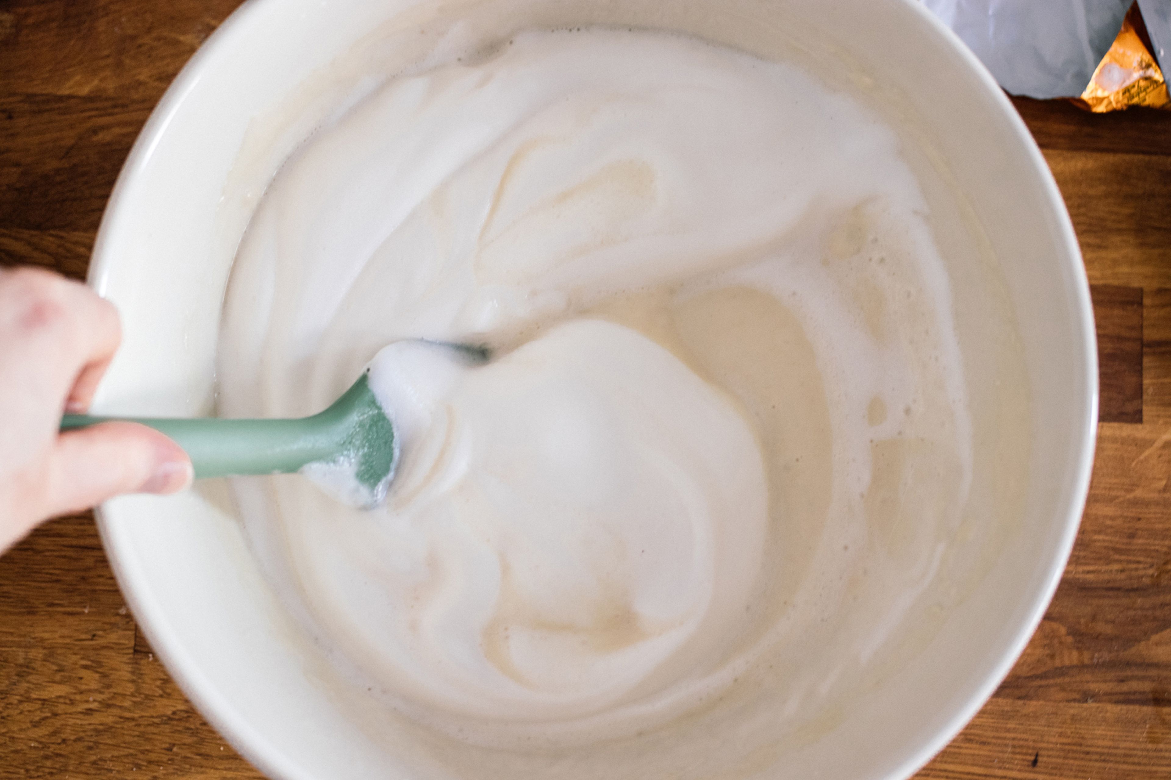 In another bowl, mix flour, sugar, and baking powder together. Add plant-based milk and melted margarine and stir until a smooth batter forms. Stir in sparkling water, then gently fold in the beaten aquafaba.