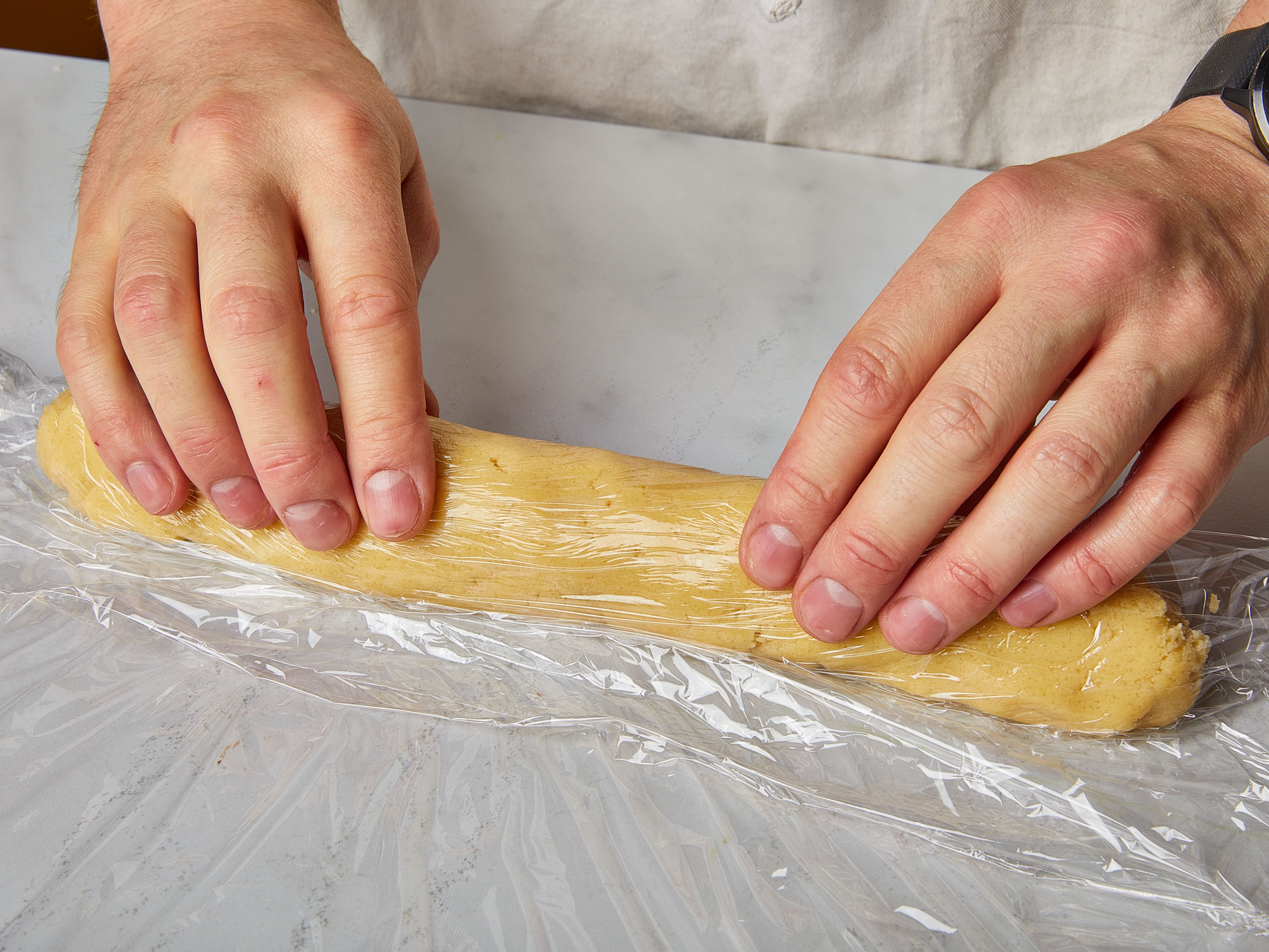 Divide the dough in half and place each half on a large piece of plastic wrap. Fold the wrap over the dough so your hands don't get sticky. Shape each half into a roll of approx. 3 cm/1 in. in diameter. Wrap tightly and place in the freezer until set, approx. 2 hrs., or overnight. If you want to bake the cookies another time, keep the dough for a week in the fridge or a month in the freezer.