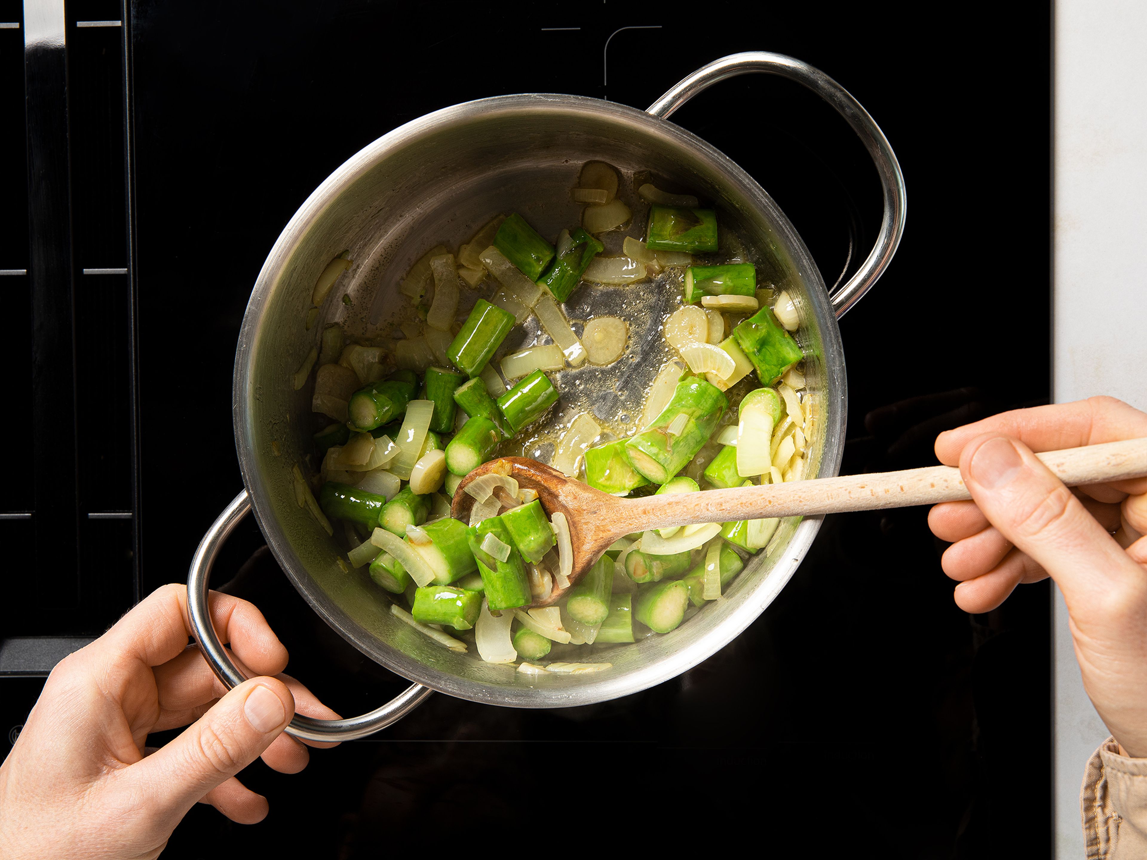Heat half the butter in a large saucepan over medium heat. Add the garlic and onions and sweat for approx. 8 min. until translucent. Add the chopped asparagus and season with a pinch of salt and some pepper. Continue to simmer for approx. 5 min, stirring occasionally.