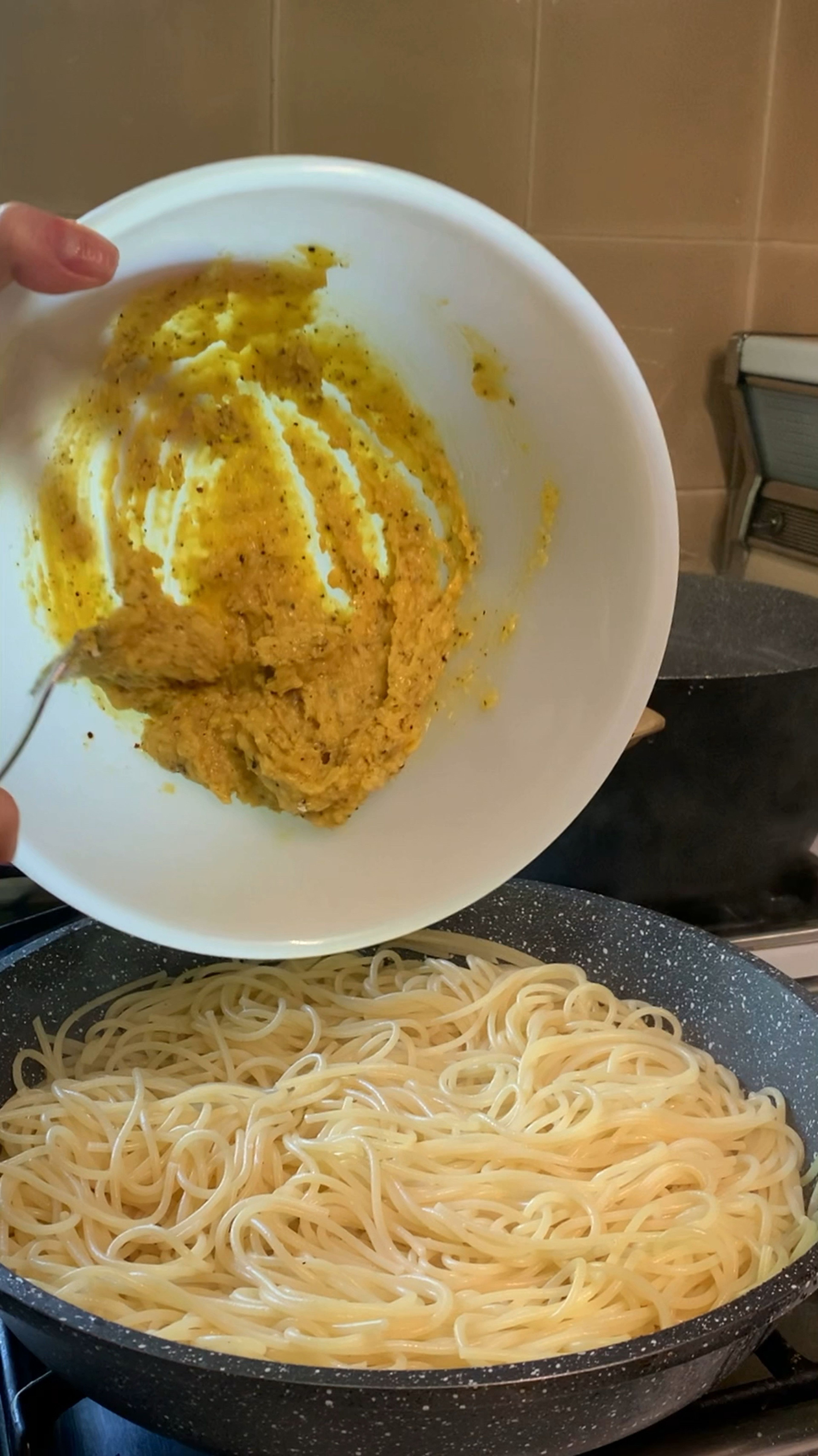 Pour cheese-yolks-pepper mixture into the pan with spaghetti.