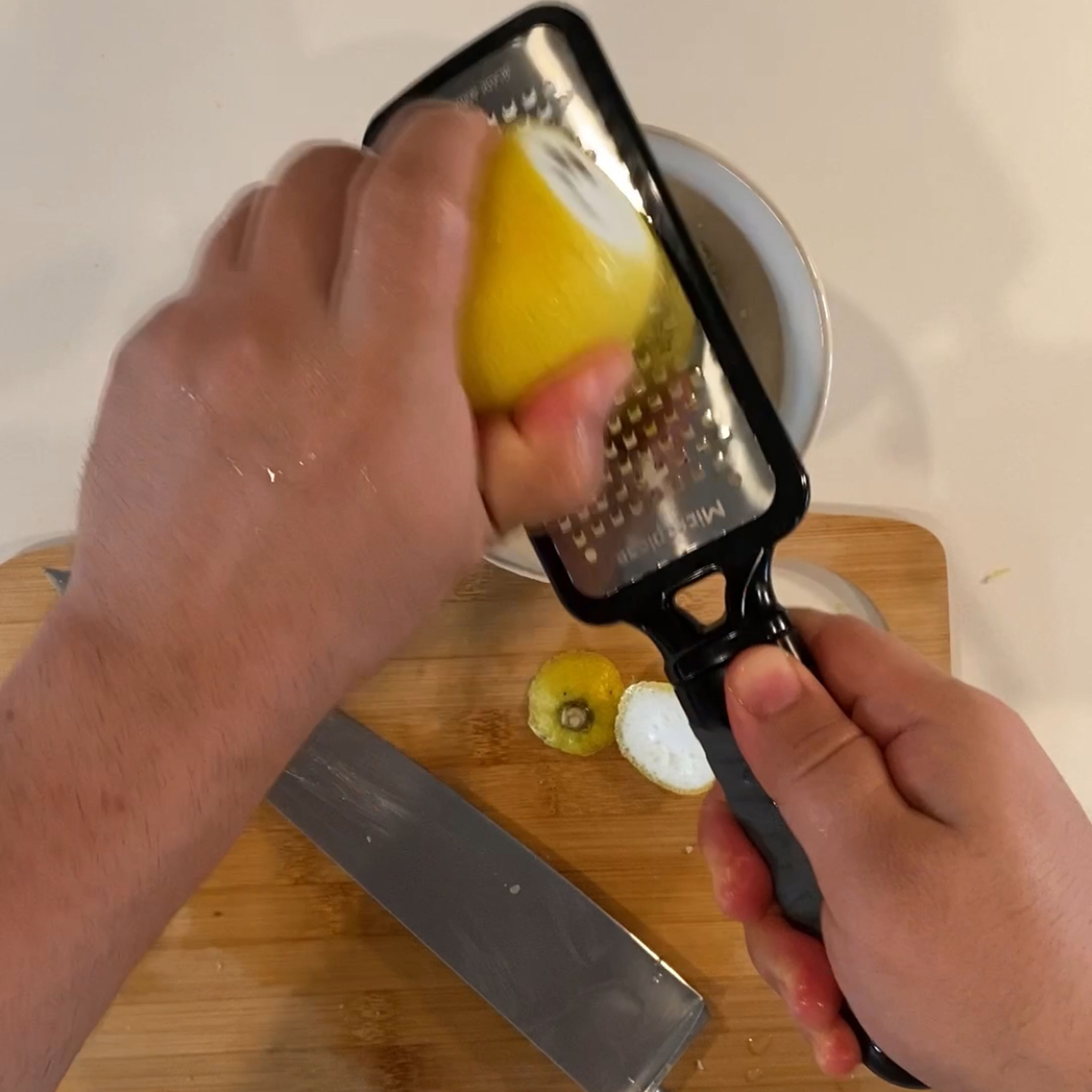 Prep some lemon zest using grater into a bowl with feta cheese