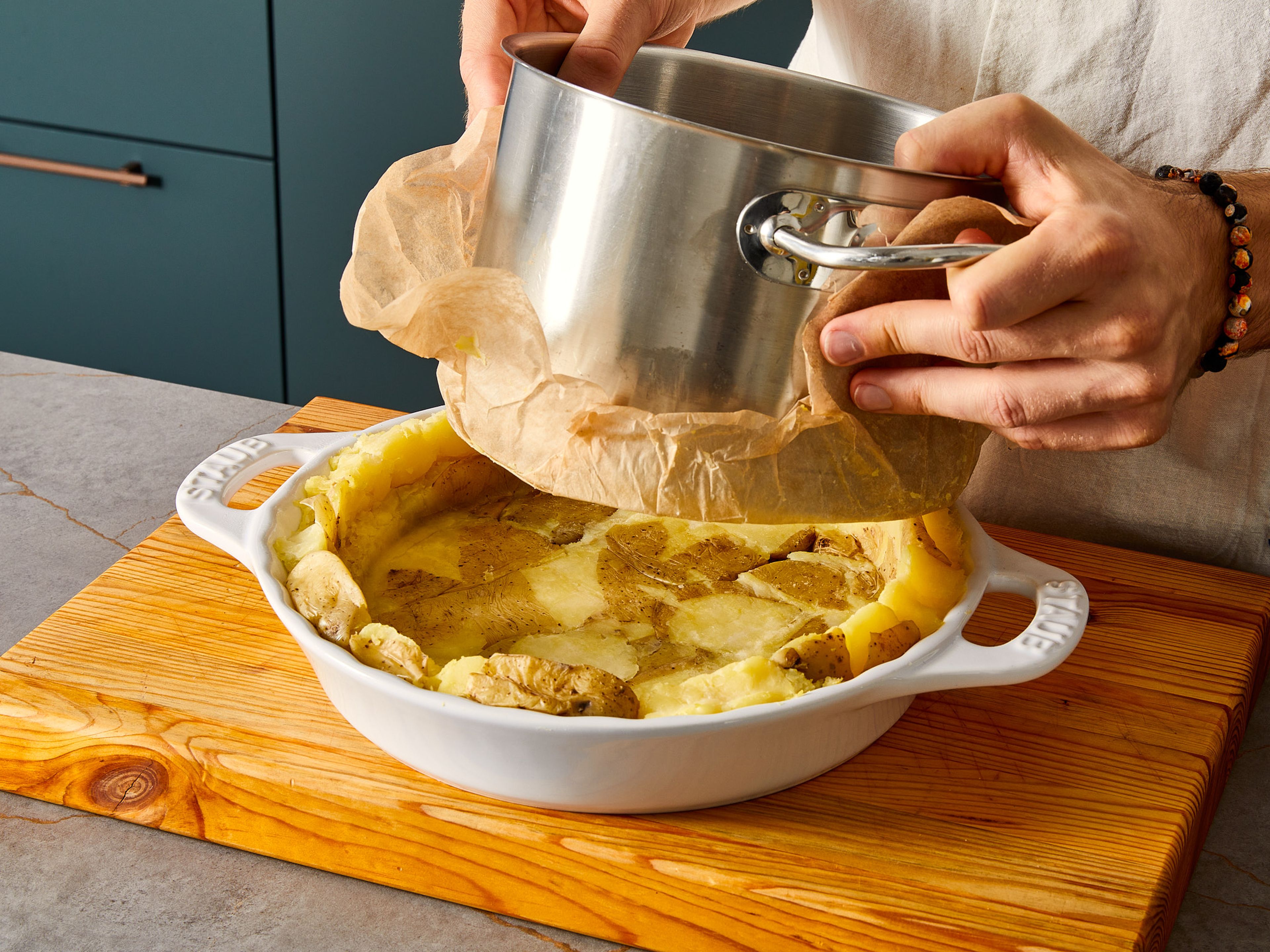 Den Ofen auf 210°C Umluft vorheizen. Die fertig gekochten Kartoffeln in eine Tarteform geben und entweder mit einem Kartoffelstampfer oder dem Boden des Topfes zerdrücken, sodass sich die Masse gut an die Form anpasst. Den Boden mit etwas Salz und Muskatnuss würzen und dann die Lauch-Creme darauf verteilen. Den Käse auf die Tarte streuen, in den Ofen geben und bei 210°C für ca. 15 Min. backen.