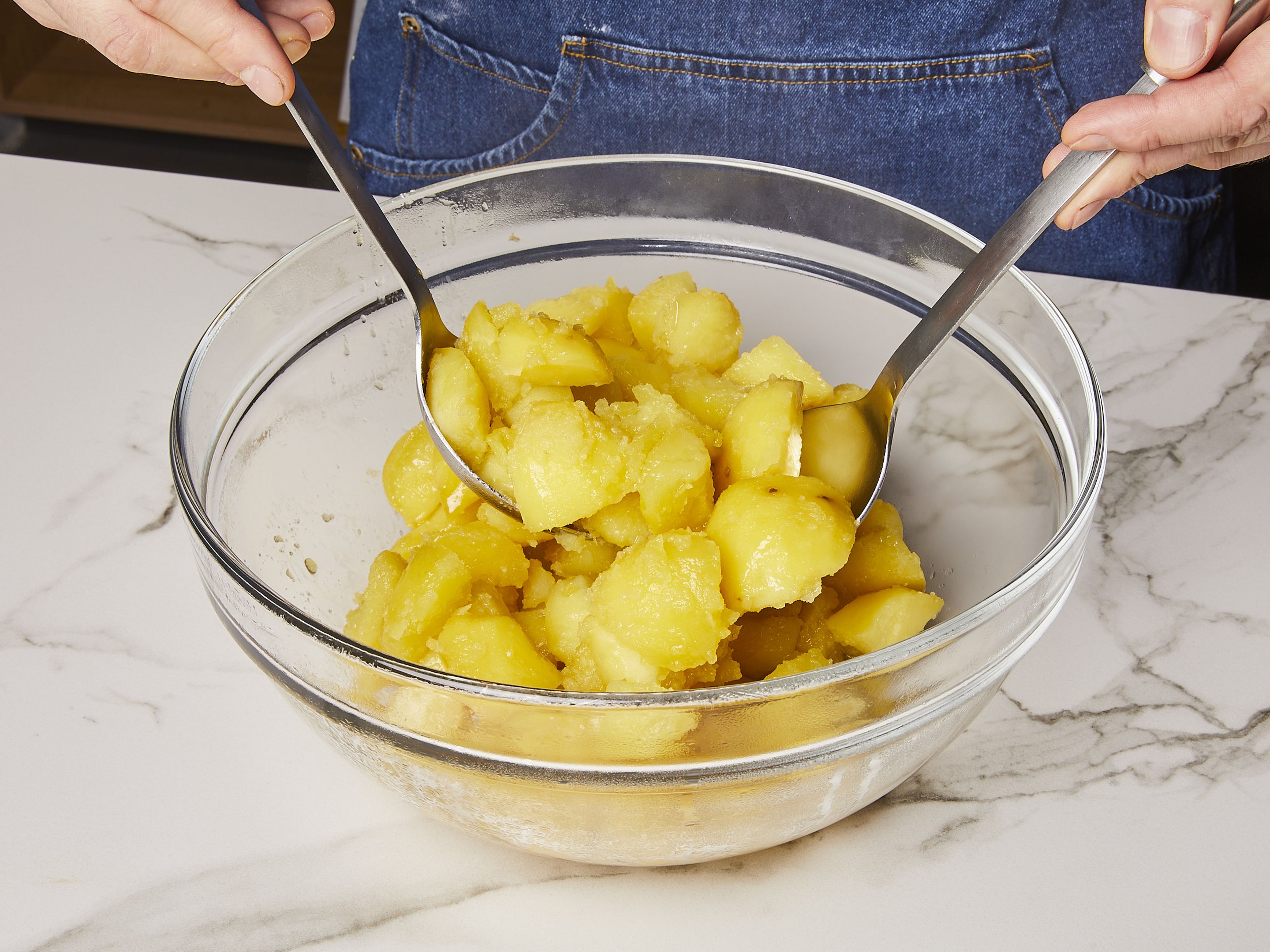 Once the potatoes are cooked, drain them in a sieve and let them rest in the pot for approx. 30 secs. to release the extra moisture. Transfer to a bowl and add oil, salt, and pepper to taste and toss them gently until they form a fluffy layer on the surface.
