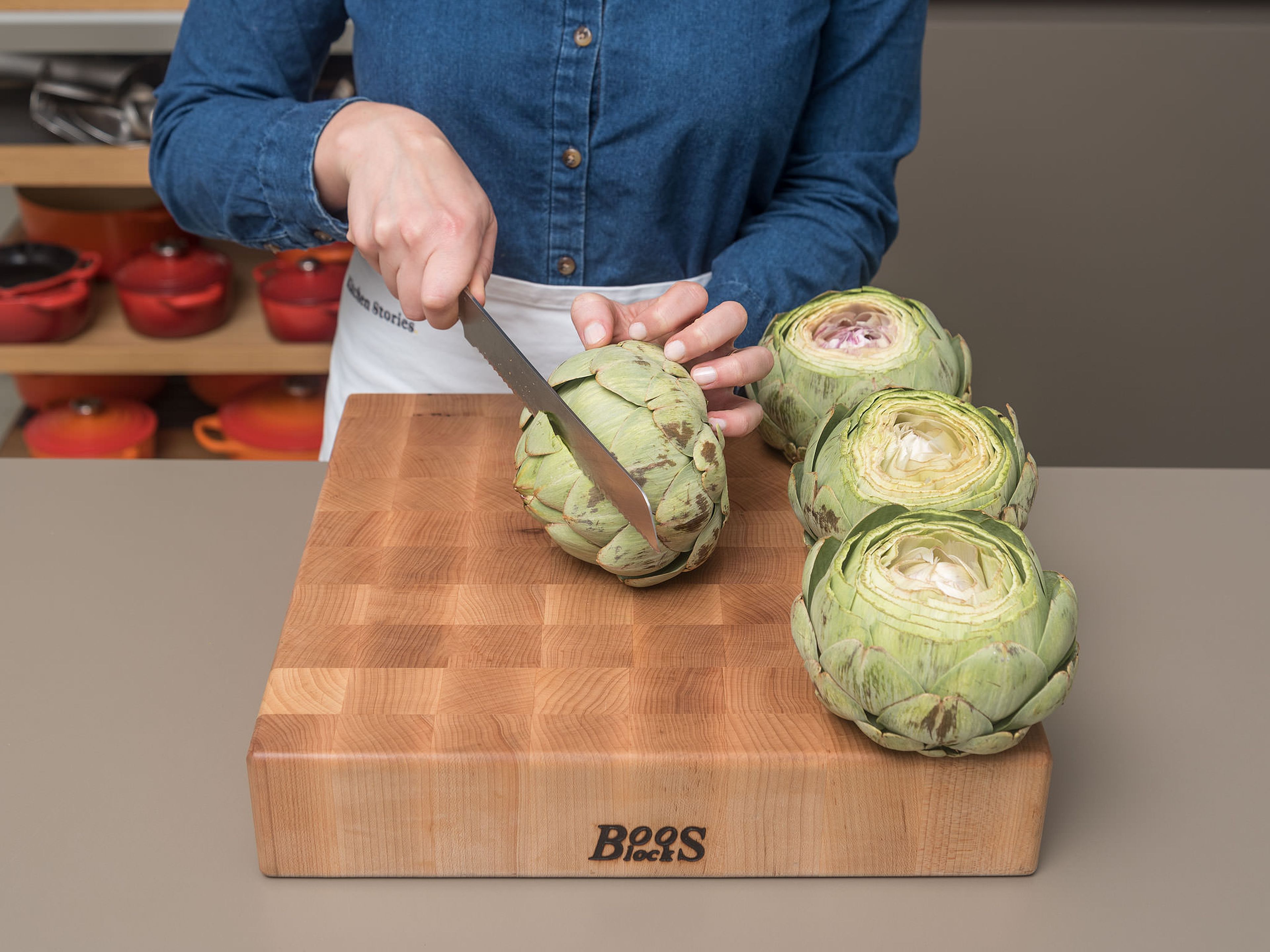 Preheat oven to 260°C/500°F. Cut off stems and top one-third of the artichokes. Gently pull leaves apart to open up the artichokes. Peel and crush garlic. Transfer artichokes to a large baking dish.