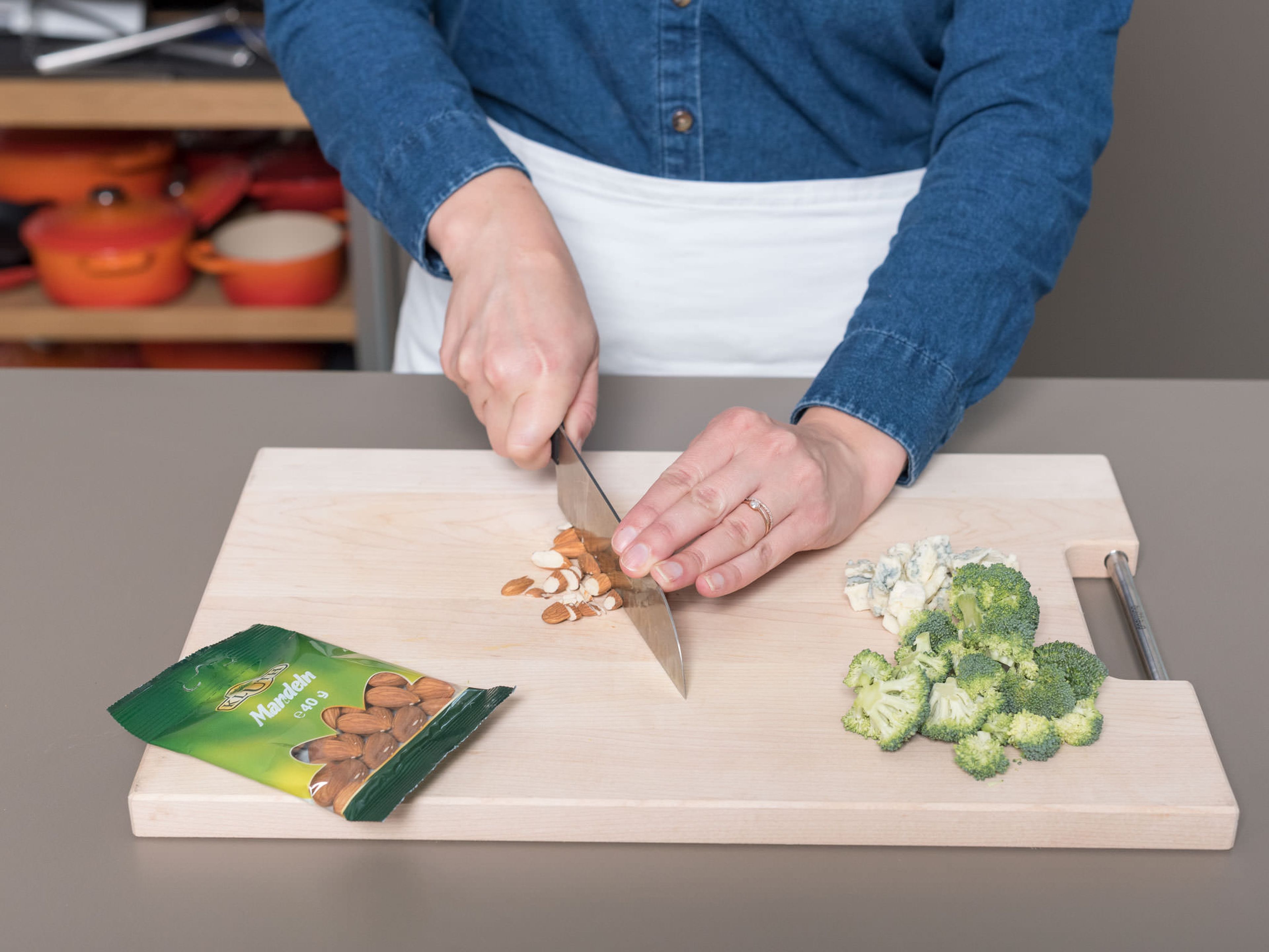 Preheat oven to 230°C/450°F. Roll out the pizza dough and place on a baking sheet lined with parchment paper, if needed. Wash broccoli, remove the stalk, and divide into small florets. Cut Gorgonzola into cubes and roughly chop almonds.