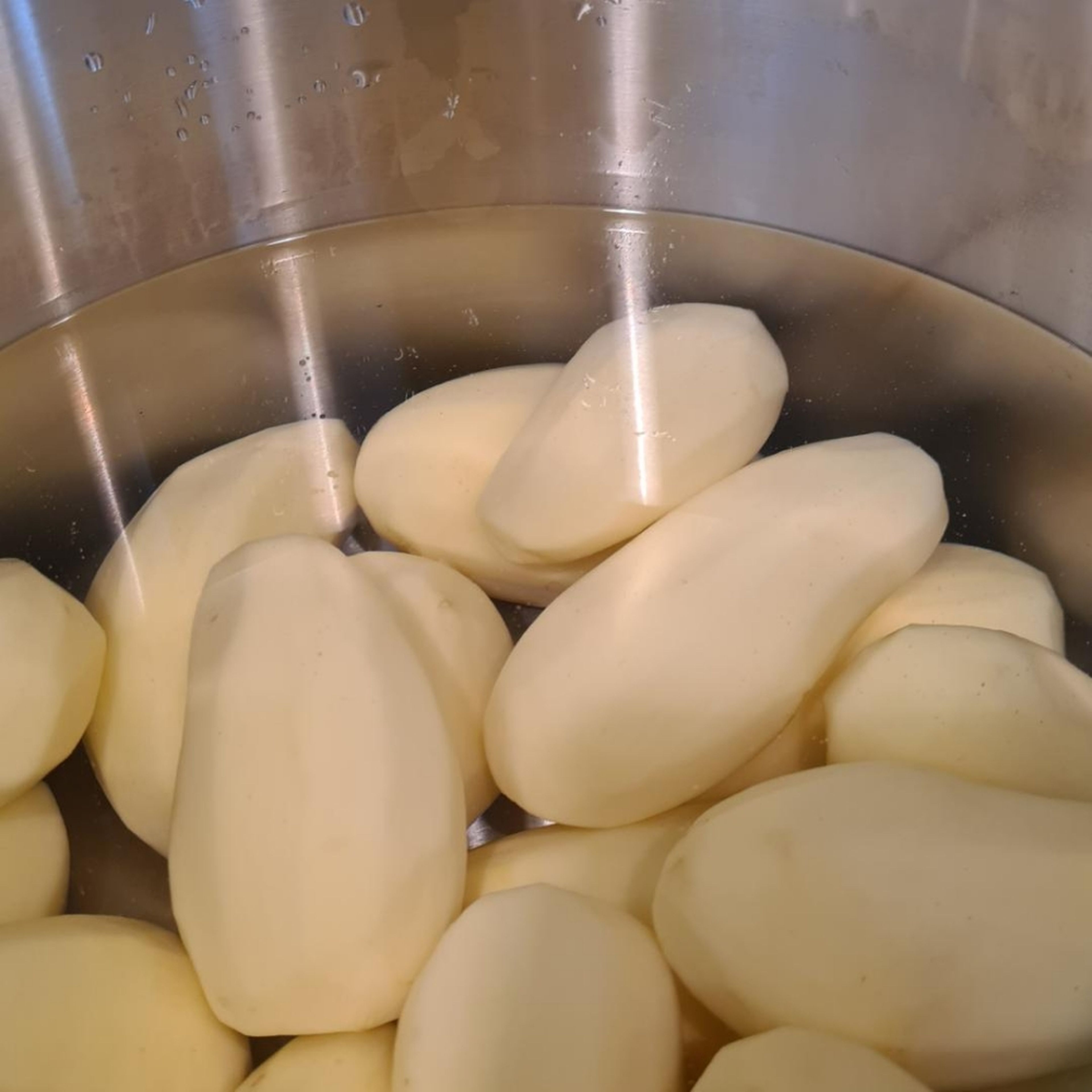 Kartoffeln schälen und dann für circa 18-20 Minuten bissfest in Salzwasser kochen.