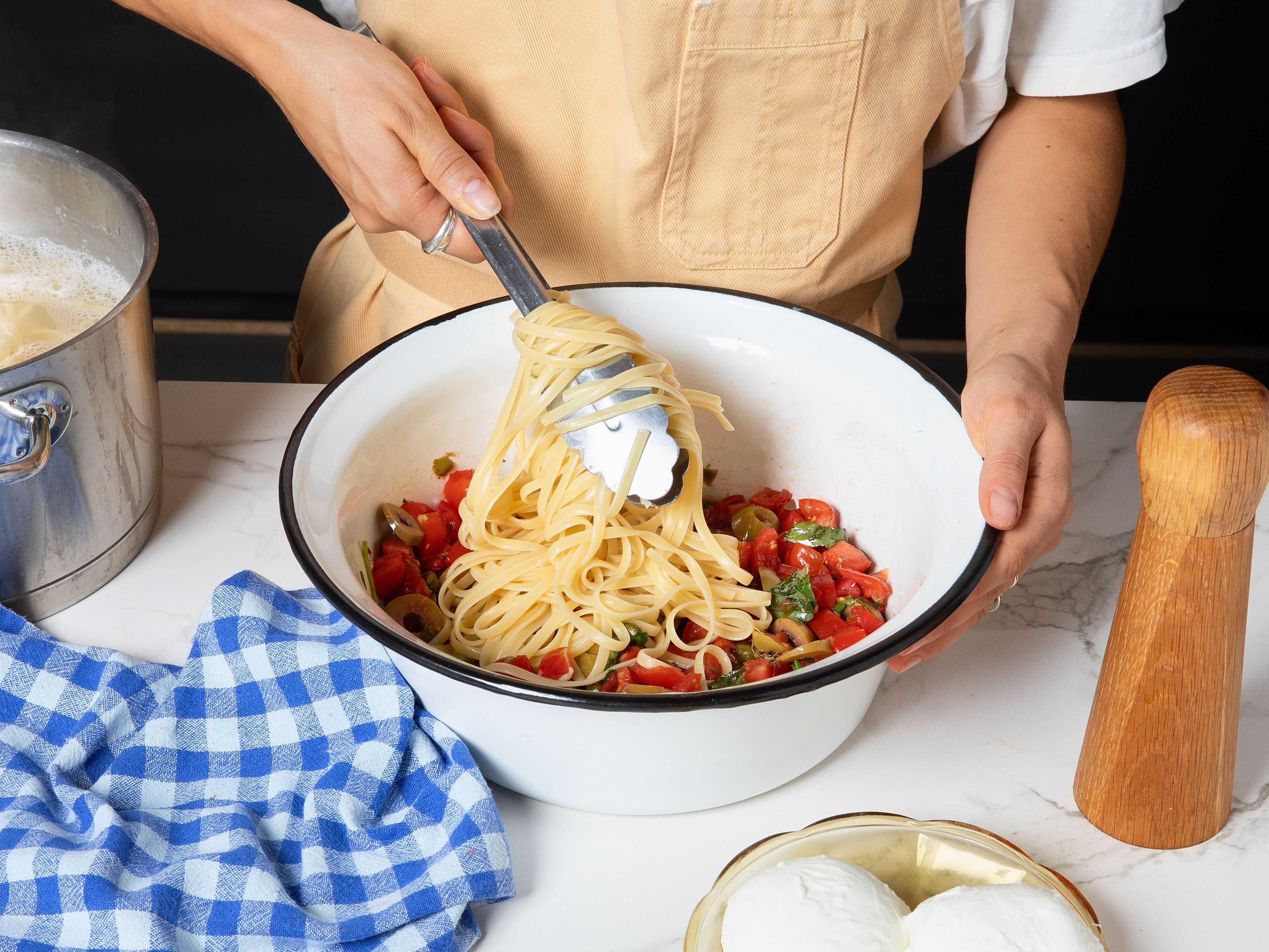 Cook the spaghetti in salted water according to package instructions until al dente. Drain and immediately add to the prepared tomato sauce. Toss well until the pasta is evenly coated, adding more olive oil if needed. Top with the remaining basil and, if desired, mozzarella. Serve immediately.