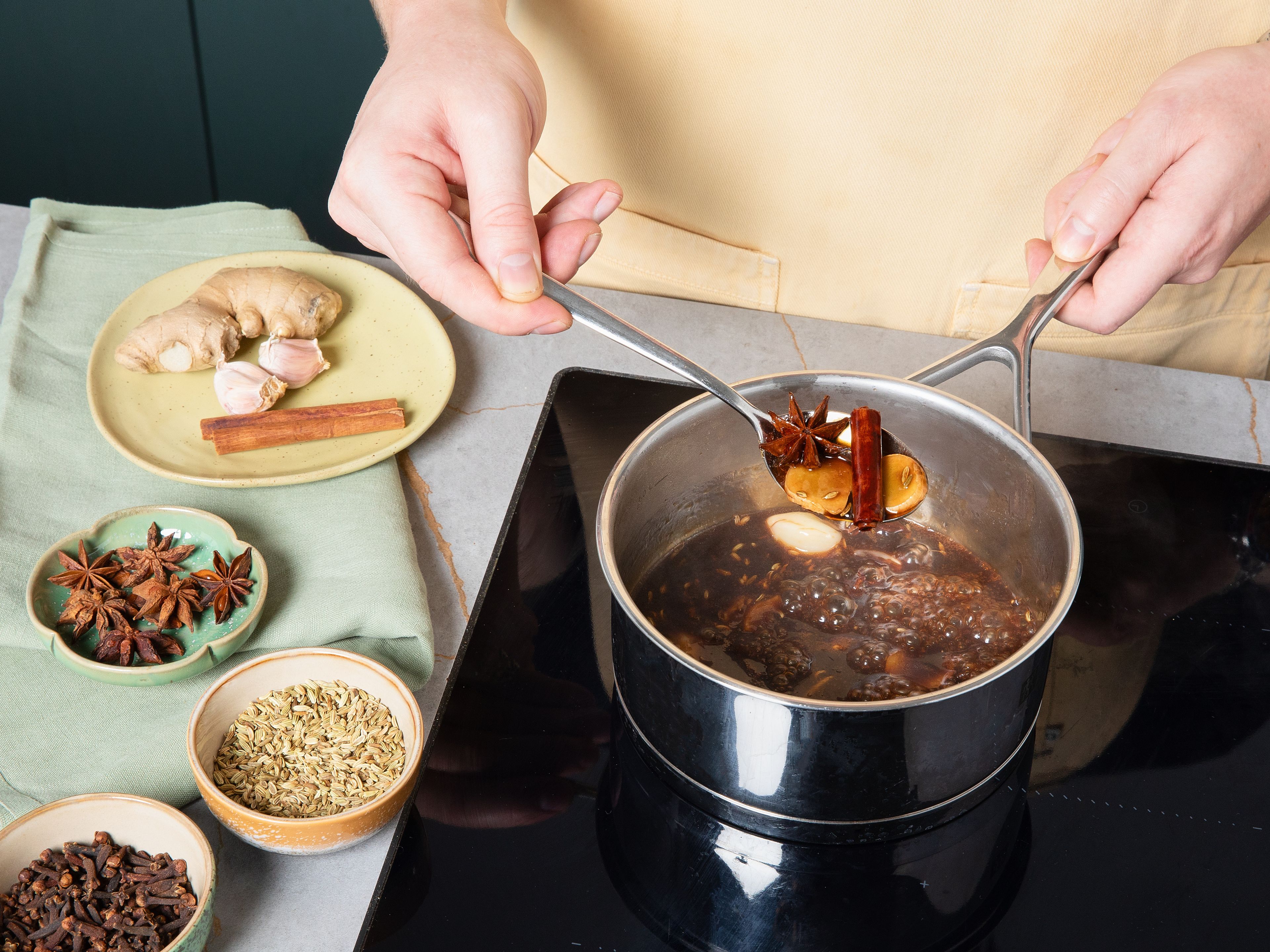 In the meantime, prepare the sauce. Peel and lightly crush garlic cloves, then slice ginger into ½ cm pieces. Heat a small saucepan on medium heat, add oil, garlic cloves, ginger, fennel seeds, cloves, star anise, and cinnamon stick; fry for approx. 30 sec. or until aromatic. Add hoisin sauce, ketchup, shaoxing rice wine, apple vinegar, soy sauce, and remaining brown sugar. Simmer for approx. 10 min., stirring occasionally. Once reduced, sieve to remove garlic, ginger, and whole spices. Set aside until ribs are finished baking.