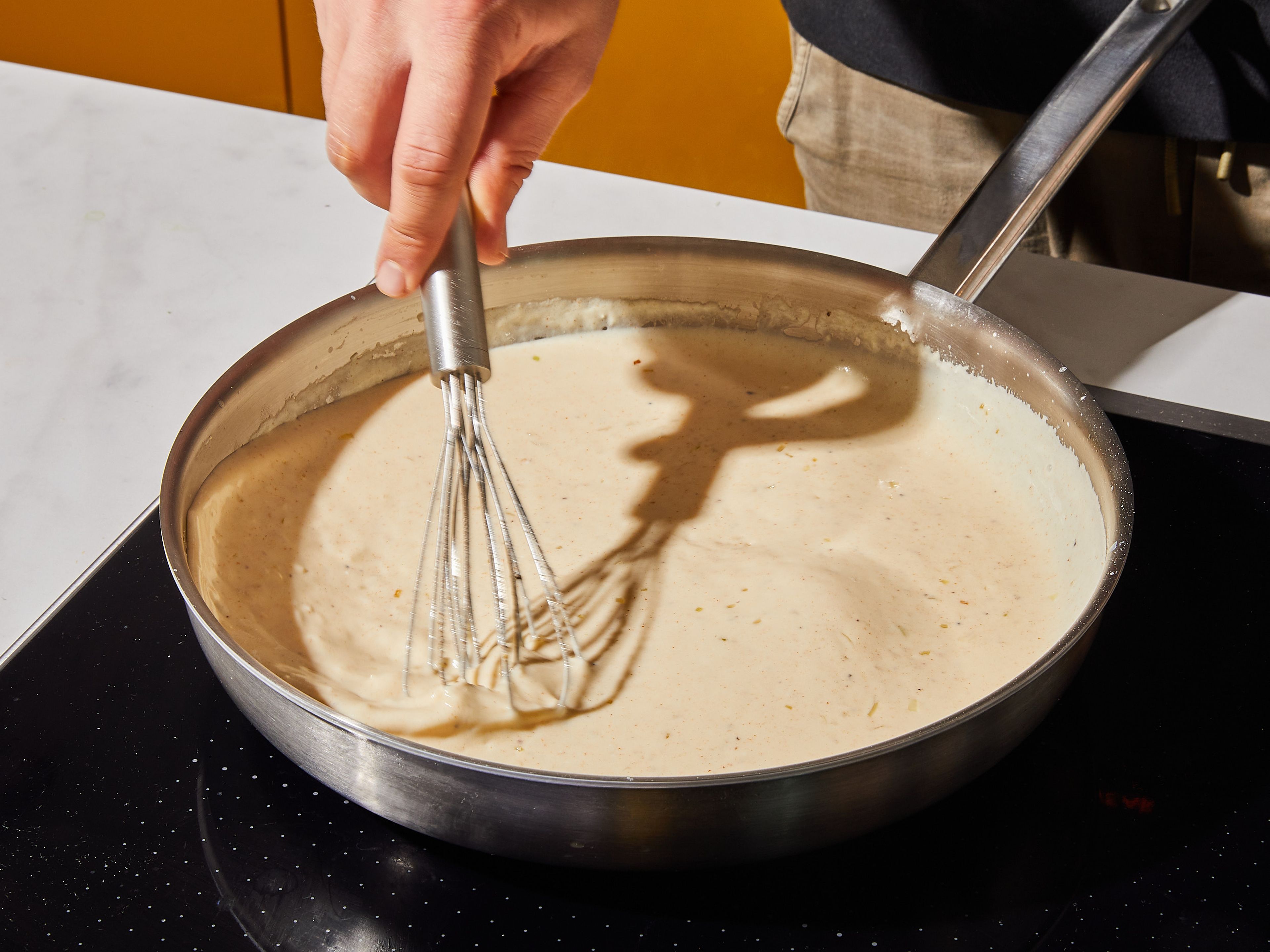Add butter to a frying pan set over medium-high heat, once melted, add the onions and garlic and sauté. Stir in the flour. Gradually pour in the milk and continue stirring until thickened.