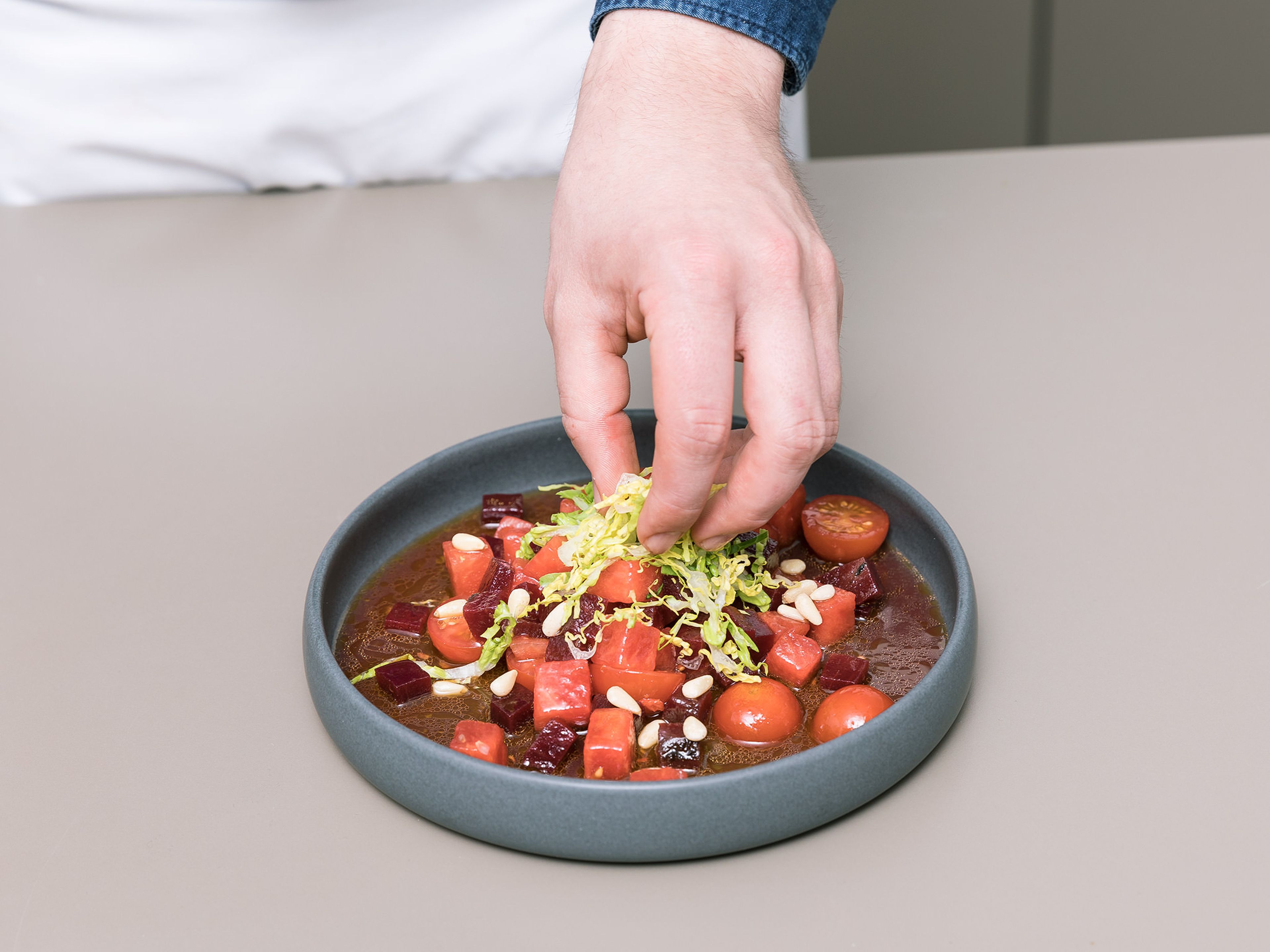 Den Salat in einer Schüssel anrichten und Balsamico-Vinaigrette darüber träufeln. Mit Römersalat und gerösteten Pinienkernen servieren. Guten Appetit!