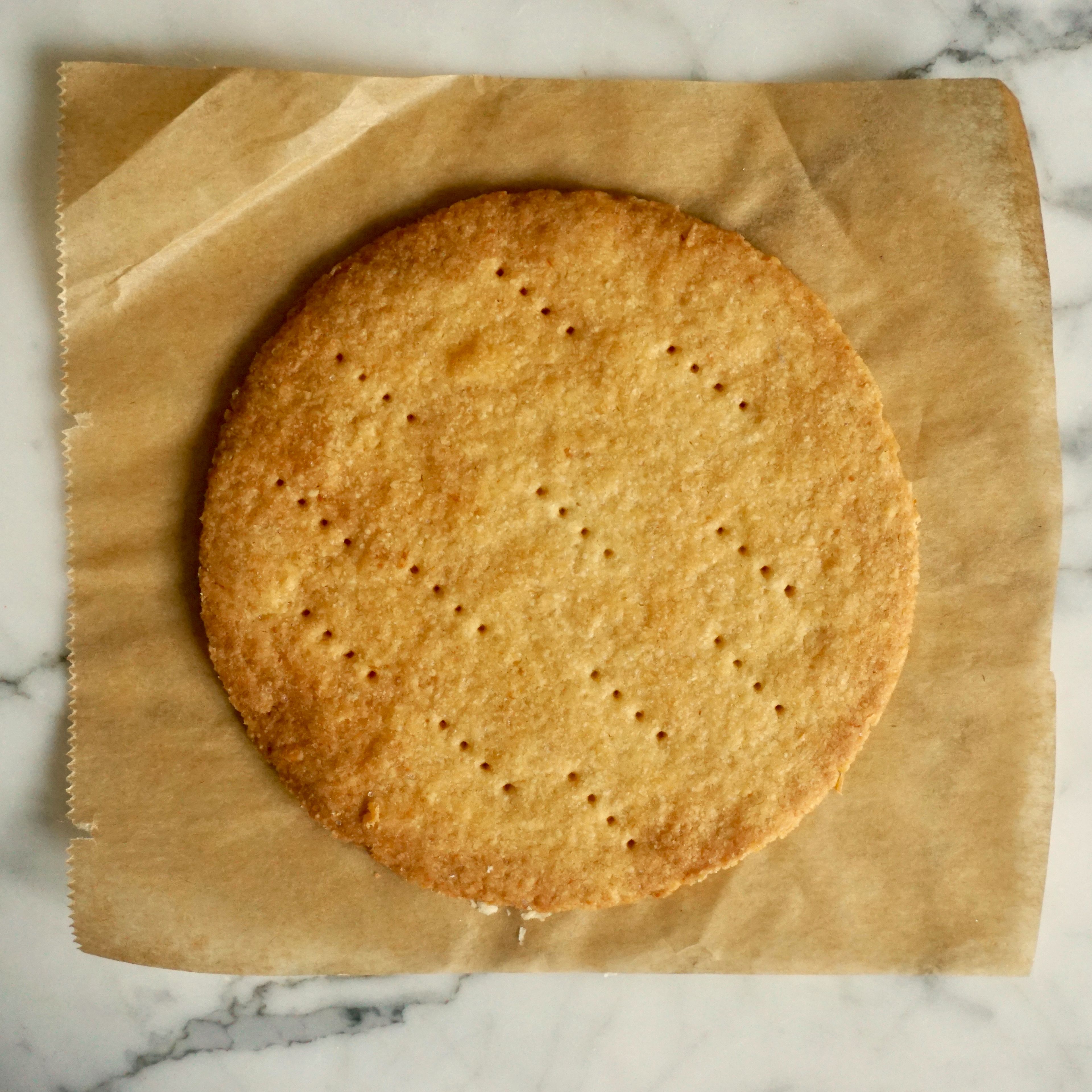 Backofen auf 180°C vorheizen. Butter mit Zucker und Salz verkneten. Dann Eigelb kurz unterkneten und zum Schluss Mehl dazugeben und solange verkneten bis ein gleichmäßiger Teig entsteht. Mürbeteig für eine halbe Stunde kalt stellen. Nach der Ruhezeit den Mürbeteig auf der bemehlten Arbeitsfläche ca. 3mm dünn ausrollen. Einen Kreis mit 14cm Durchmesser ausstechen und mit einer Gabel einstechen. Auf ein Backblech mit Backpapier legen und für 15 Minuten backen.