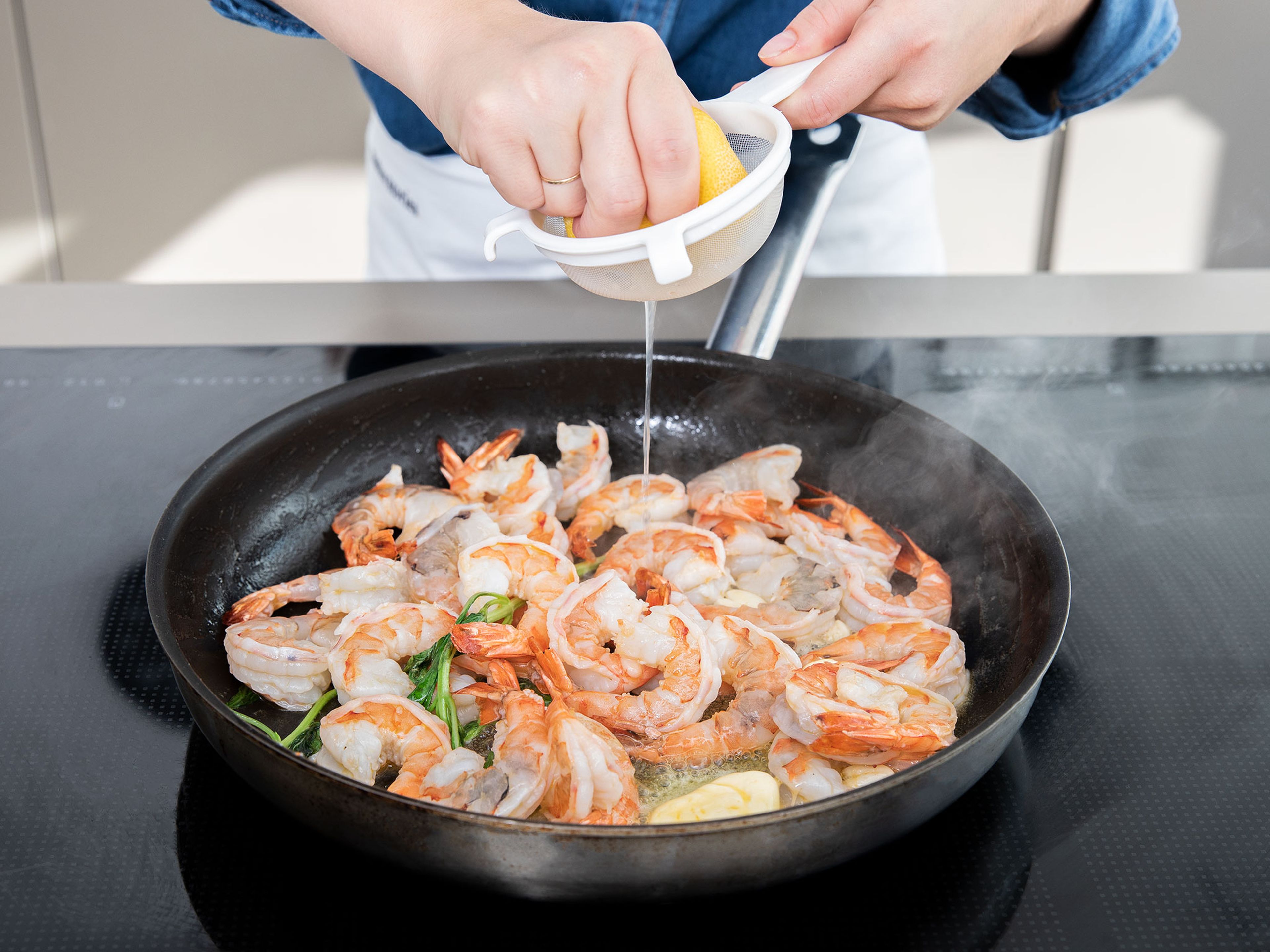 Heat remaining olive oil in a large frying pan and fry shrimp for approx. 1 – 2 min. or until cooked through. Add remaining butter, remaining garlic clove, basil, and lemon juice. Season with salt and pepper. Serve risotto with shrimp on top. Enjoy!