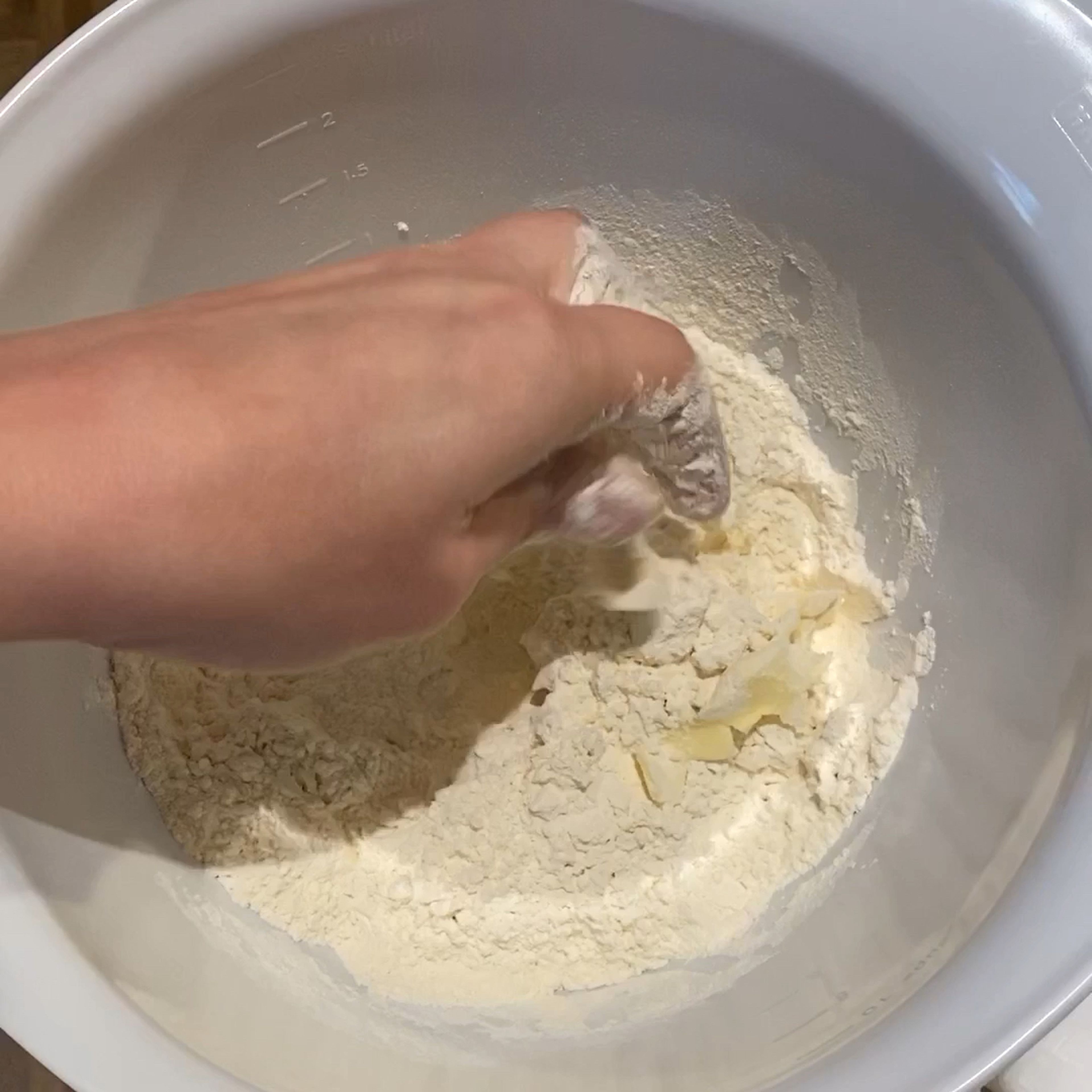 Mehl, Salz, Zucker und Backpulver in einer großen Rührschüssel vermischen. Gewürfelte kalte Butter hinzufügen und mit den Fingern in das Mehl einarbeiten.Die Butter gut ummanteln und nach und nach in walnussgroße Stücke zerkrümeln.