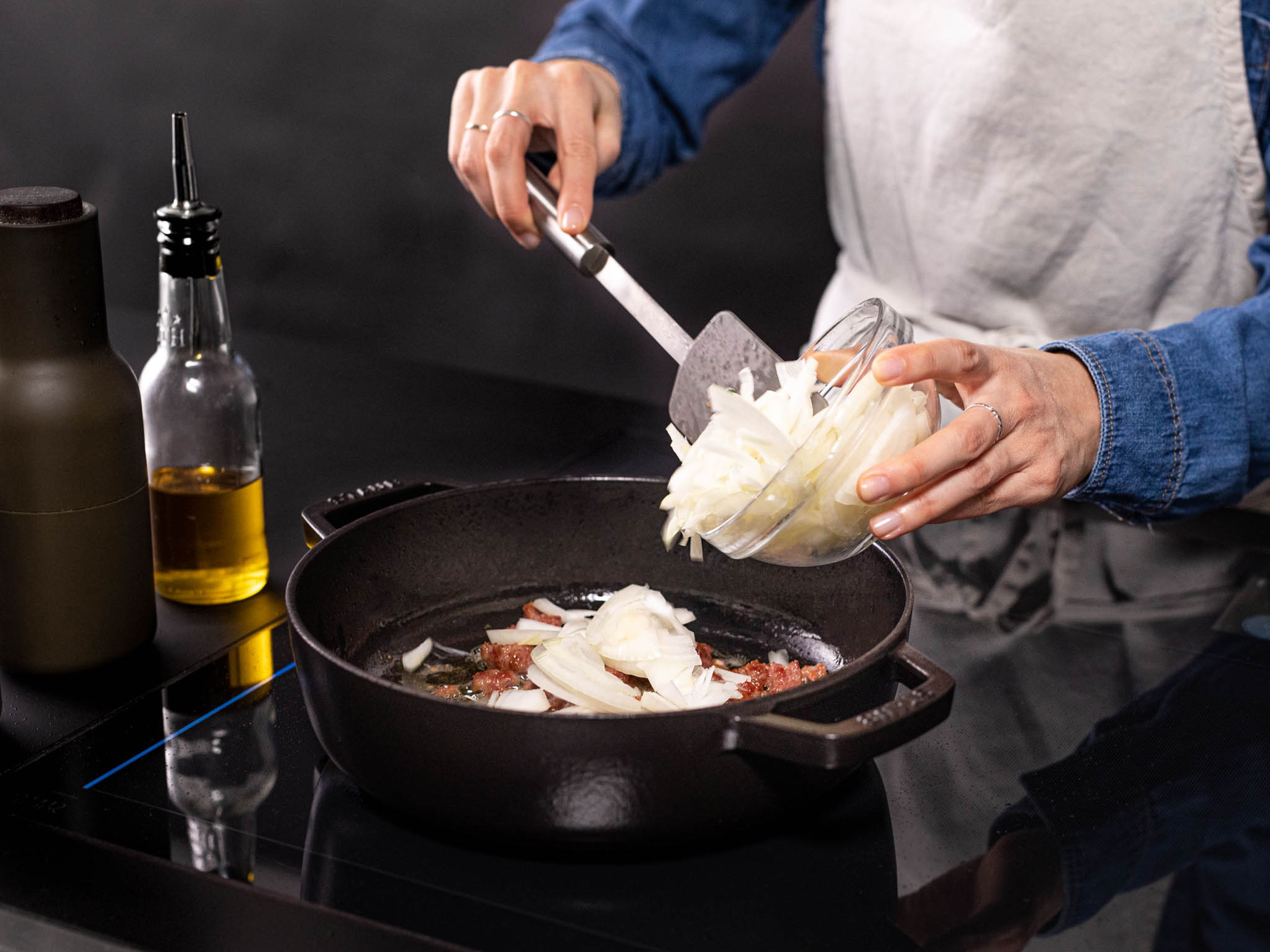 Etwas Olivenöl in eine ofenfeste Pfanne geben und auf mittlerer bis hoher Stufe erhitzen. Die Wurst zugeben und für ca. 8 Min. anbraten. Jetzt die Zwiebeln hinzufügen und unter häufigem Rühren ca. 15 Min. garen, oder bis die Zwiebeln anfangen zu karamellisieren. Mit Salz und Pfeffer abschmecken.