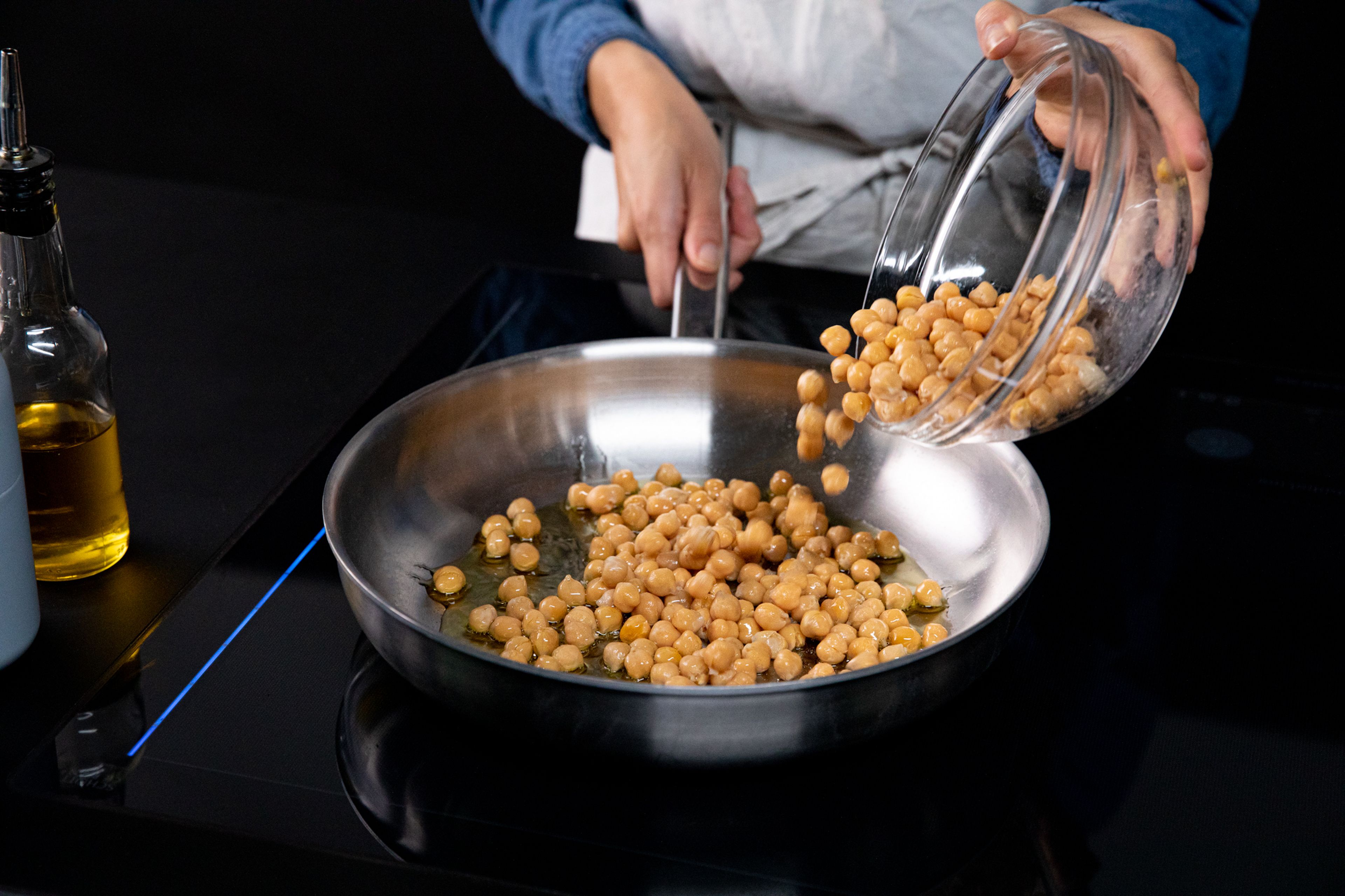 Set a frying pan over medium heat and add some oil. Add drained chickpeas and fry until slightly browned, approx. 5 - 7 min. Season with salt and pepper. Divide the chickpeas equally into two bowls. Mash one bowl of chickpeas well with a fork. Add some olive oil, tahini, and lemon juice to the mashed chickpeas, and mix well to combine.