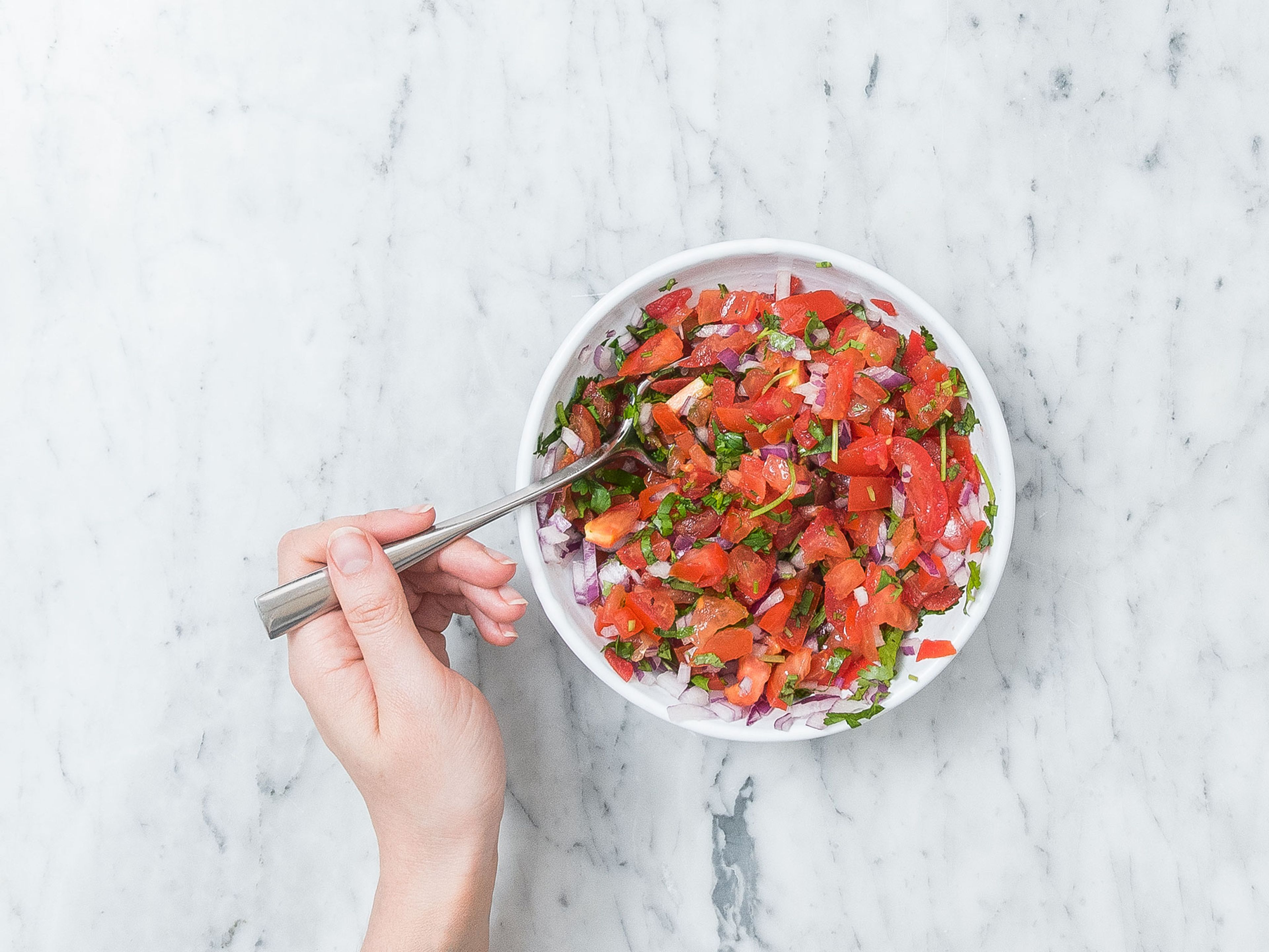 Halve tomatoes, remove seeds and finely dice. Peel and finely dice red onion. Finely chop cilantro. Add tomatoes, red onion and cilantro to a mixing bowl and stir to combine. Set aside.