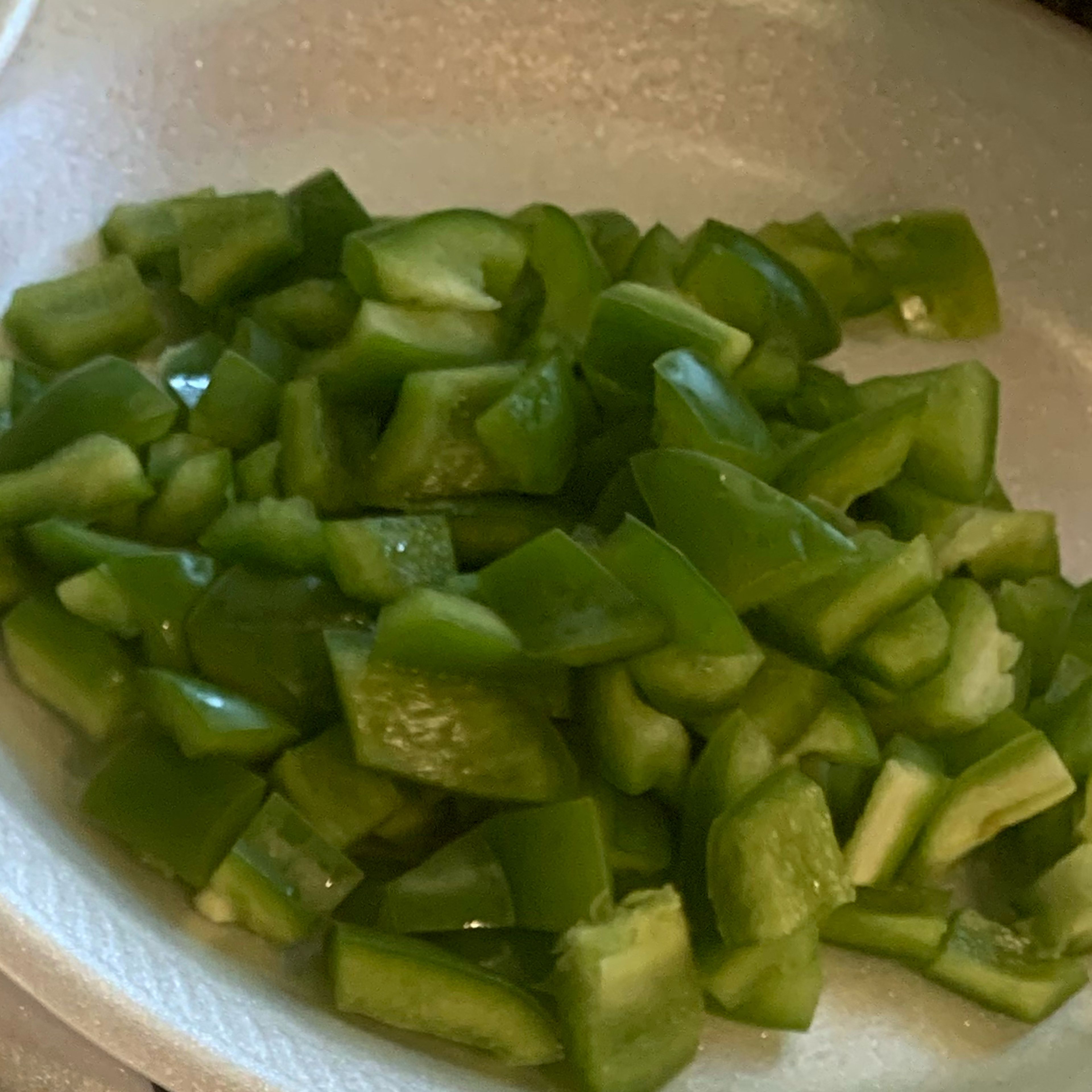 Rinse your bell peppers and then chop them into a medium dice being sure not to keep any of the ribs and seeds. Next rinse your green onion and then chop off the hairy ends. From the bottom of the scallion and up you’ll chop them and you’ll then set them aside for later use if desired.