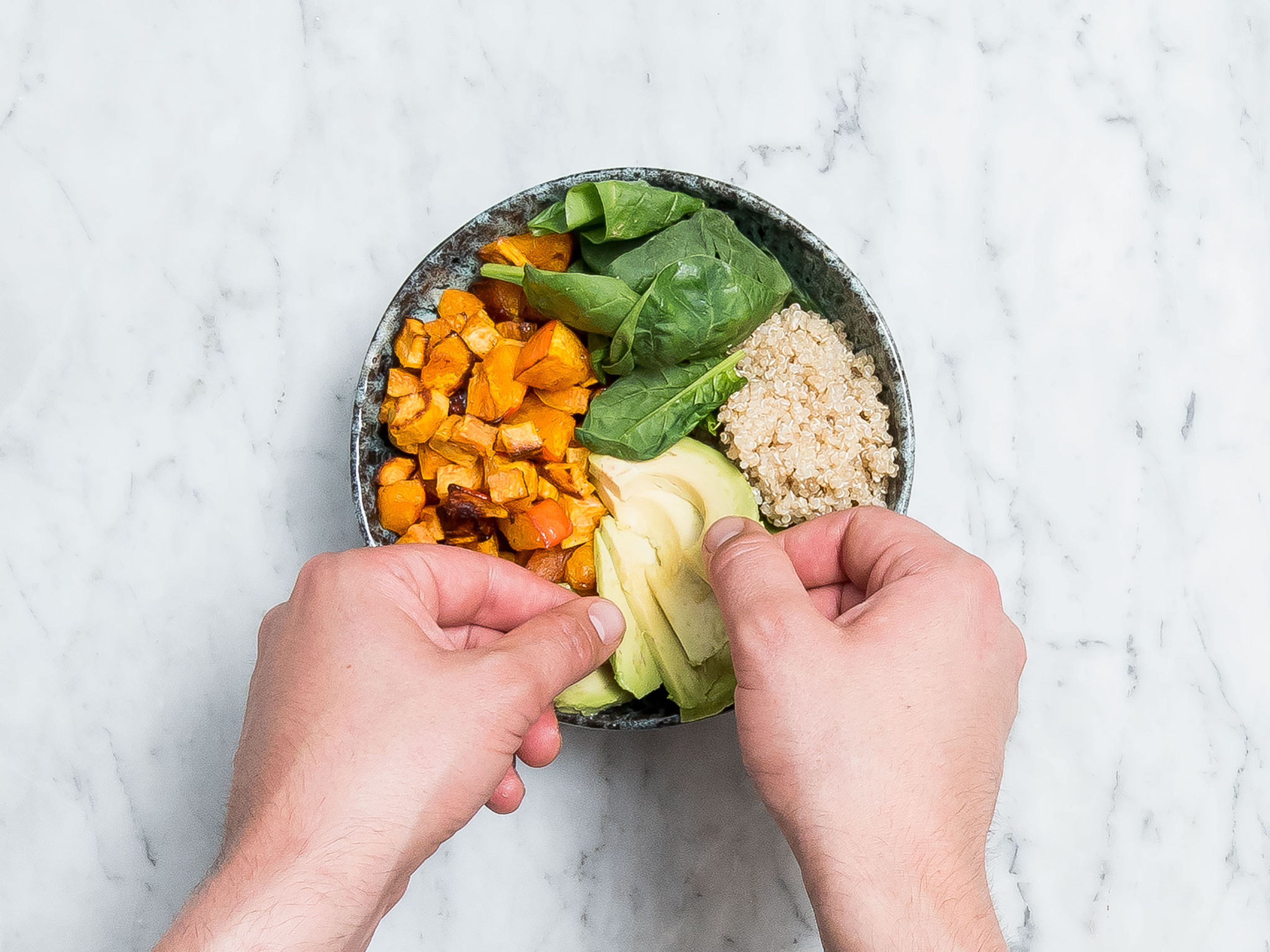 Wash and dry baby spinach. Halve, pit and slice avocado. Serve spinach, cooked quinoa, pumpkin and sweet potato, avocado, and pepper-orange topping to a serving bowl. Enjoy!