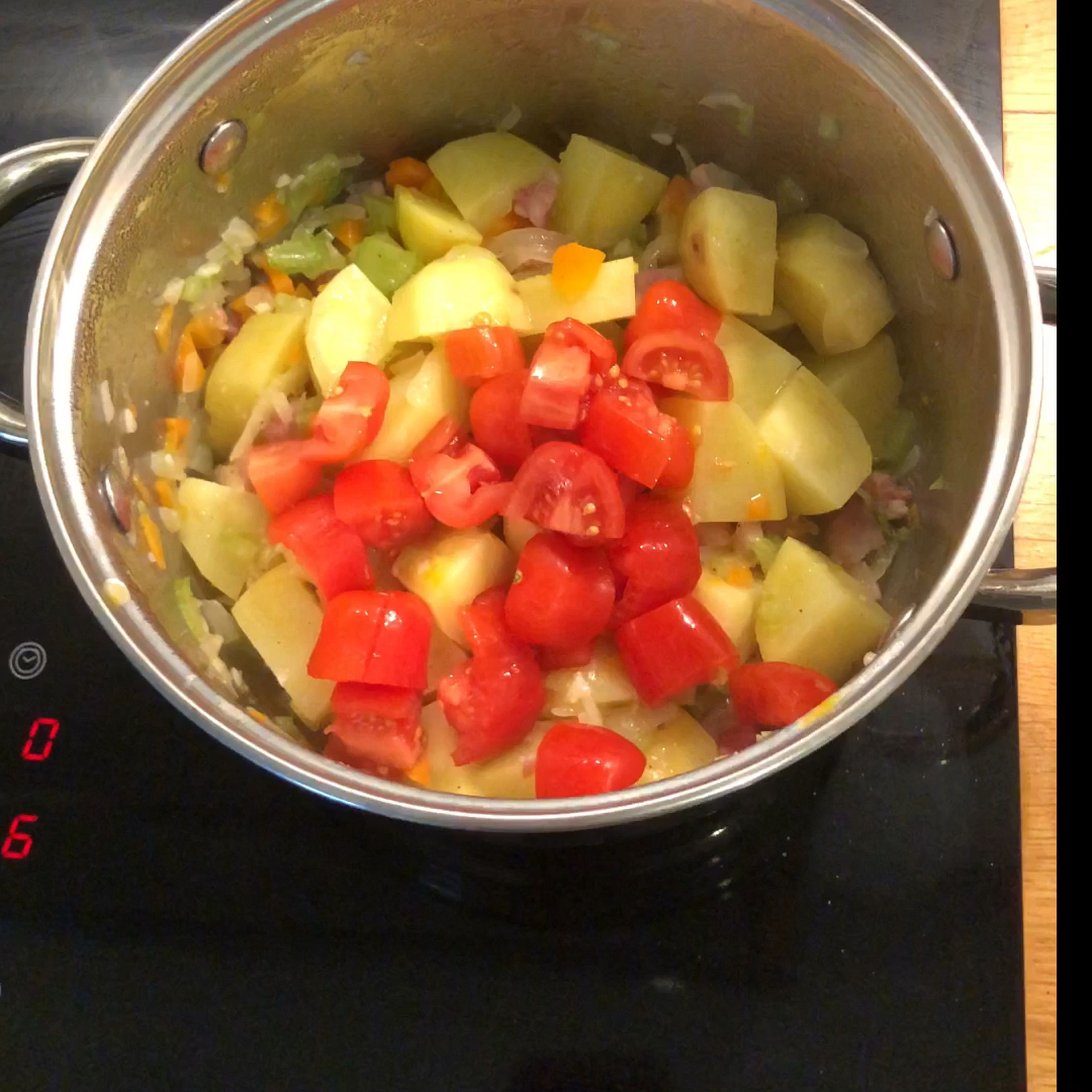 After 10 minutes, cut the potatoes in small pieces and add to the soffritto, together with the tomatoes, a pinch of salt and pepper. Stir everything, cover with a lid and cook for 20 minutes at low-mid heat. Be careful to not burn because it’s cooking with no water, potatoes should stick to the pot but not burn, for that you should stir frequently.