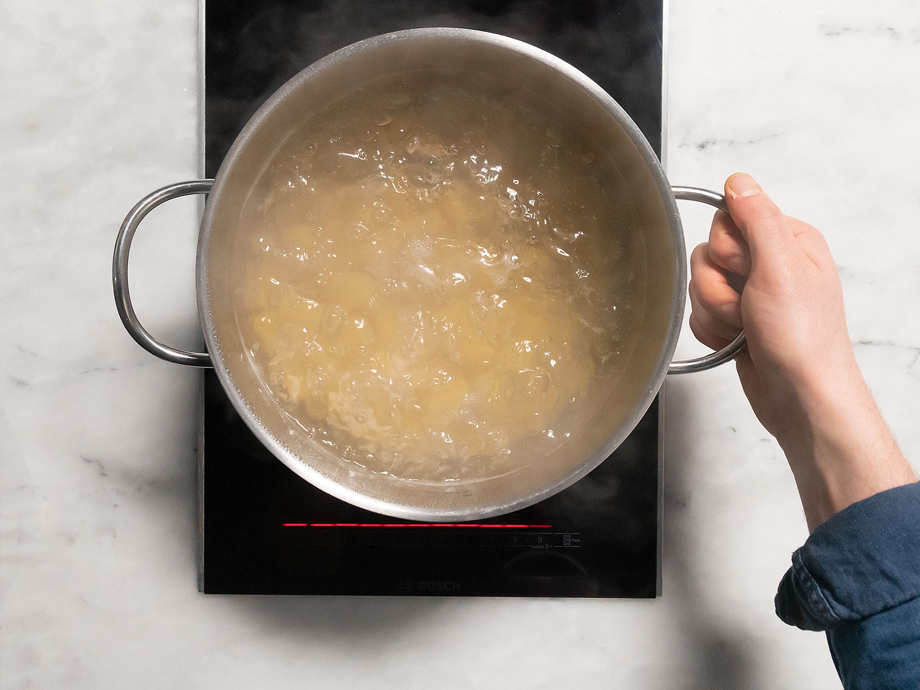 Speck in Würfel schneiden und Kirschtomaten halbieren. Wasser in einem großen Topf bei mittlerer bis hoher Hitze aufkochen lassen und salzen. Rigatoni nach Packungsanleitung kochen. Vor dem Abgießen etwas vom Kochwasser abschöpfen und beiseitestellen.