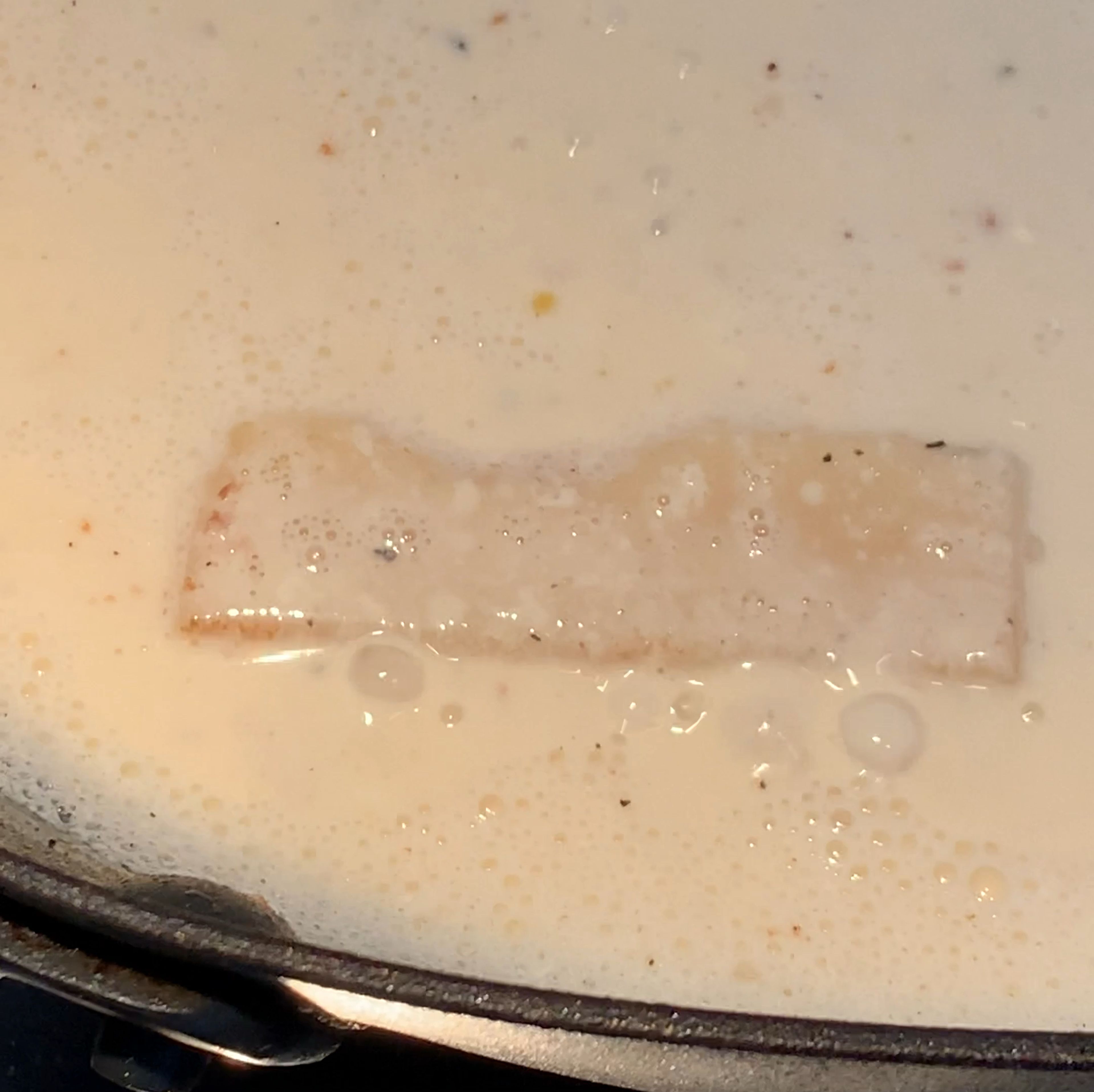 Den Bratensatz in der Pfanne mit Weißwein ablöschen und kurz aufkochen lassen. Sahne, Hühnerbrühe und, falls vorhanden, ein Stück Parmesanrinde hinzugeben und bei niedriger bis mittlerer Hitze ca. 10 Min. einkochen lassen. Währenddessen die Pasta in sprudelndem Wasser weich, aber nicht ganz fertig kochen. Abgießen und kurz abschrecken, falls die Soße noch nicht fertig ist.