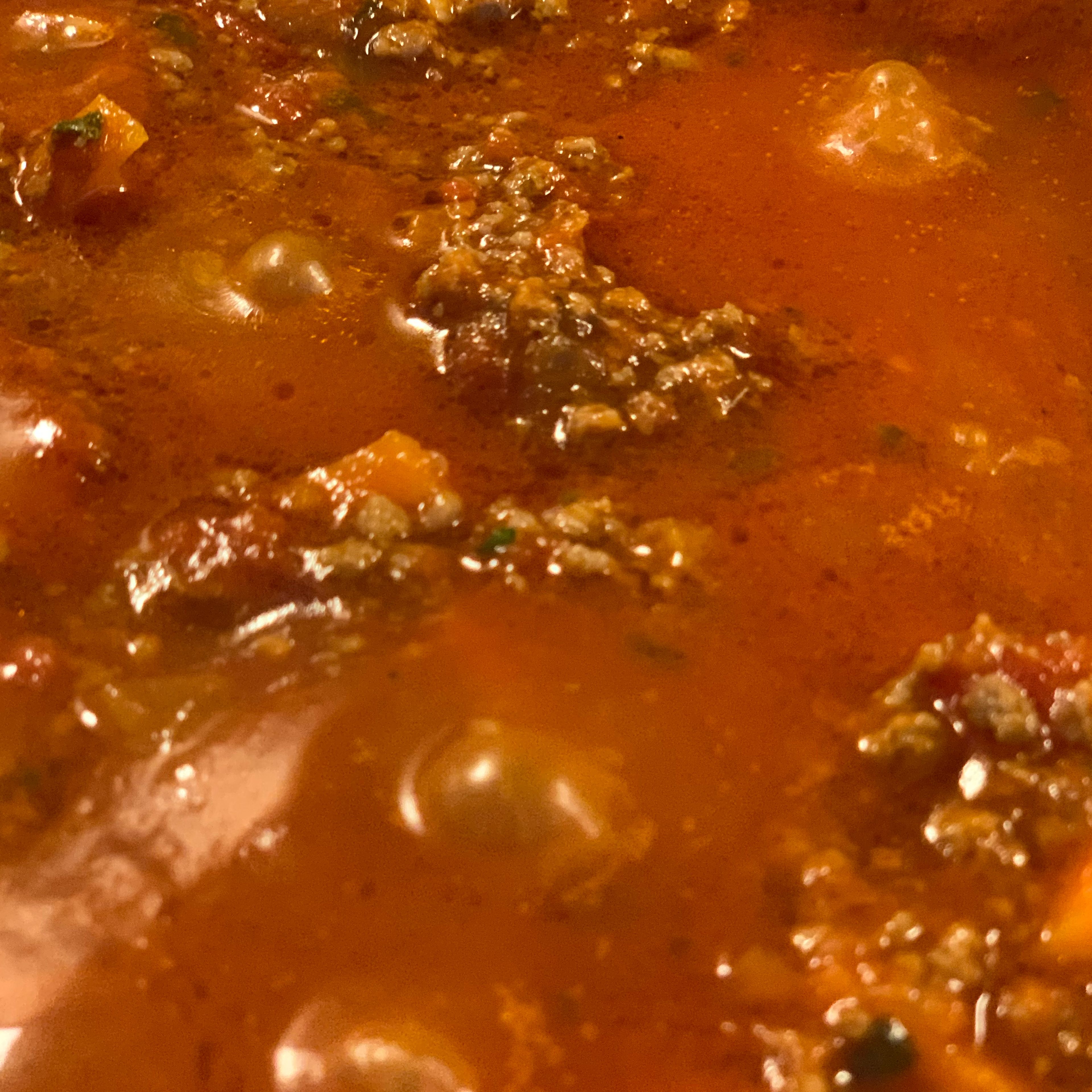 Die Masse mit Tomatensauce „ablöschen“. Danach die Thymianzweige und Lohrberblätter in die Pfanne hinzufügen und mit Oregano würzen. Nun die Sauce auf tiefer Stufe zugedeckt köcheln lassen so das sie warm bleibt bis zum servieren.