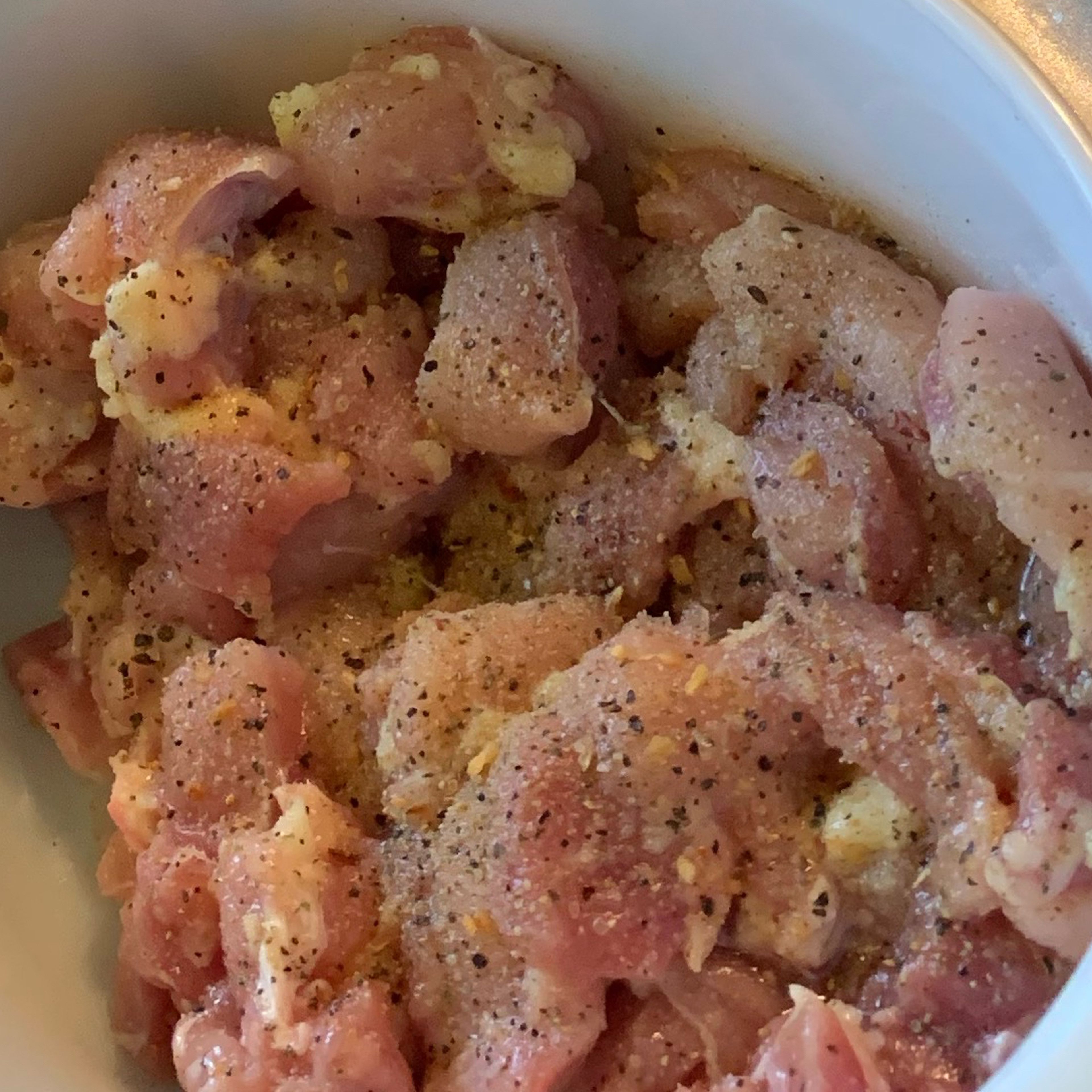 Rinse your chicken thighs under cold water and then pat them dry of any excess water. Next, cut them into small pieces to your desired likeness. Cover them in olive oil along with your all purpose seasoning blend then set aside to quickly marinate.
