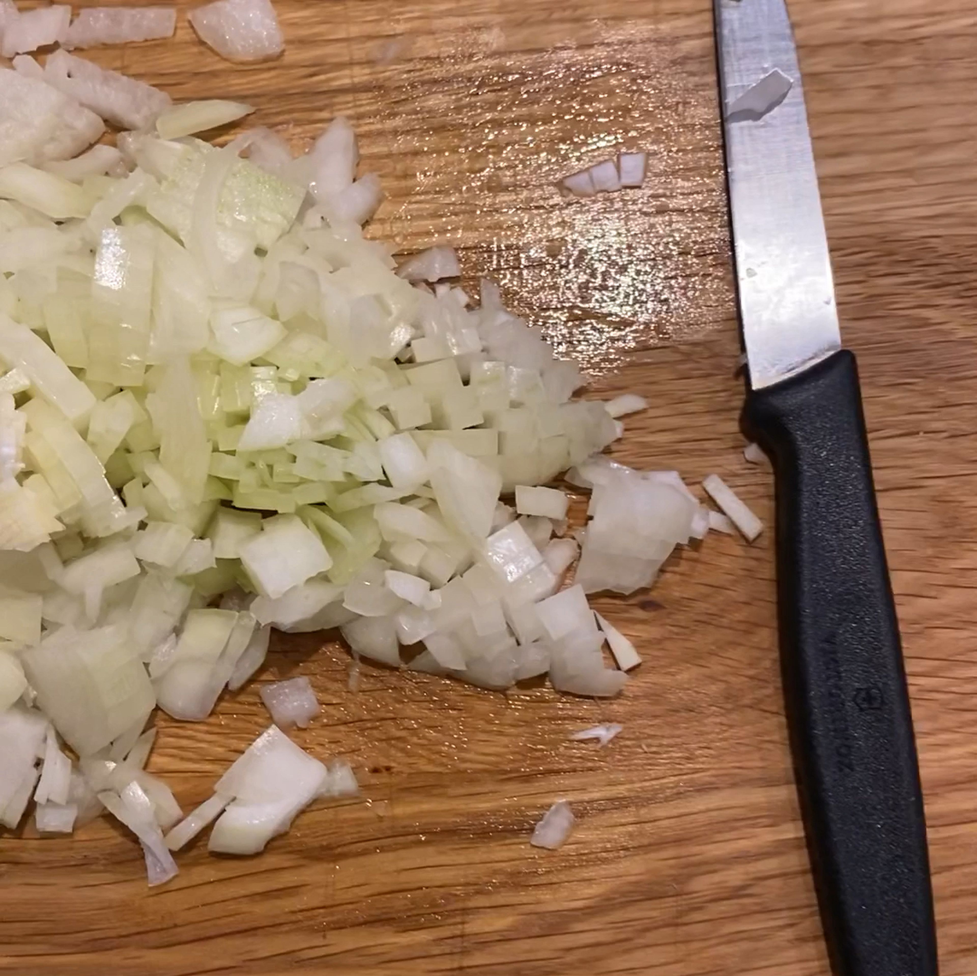 In der Zwischenzeit Zwiebeln und Knoblauch schälen und kleinschneiden.