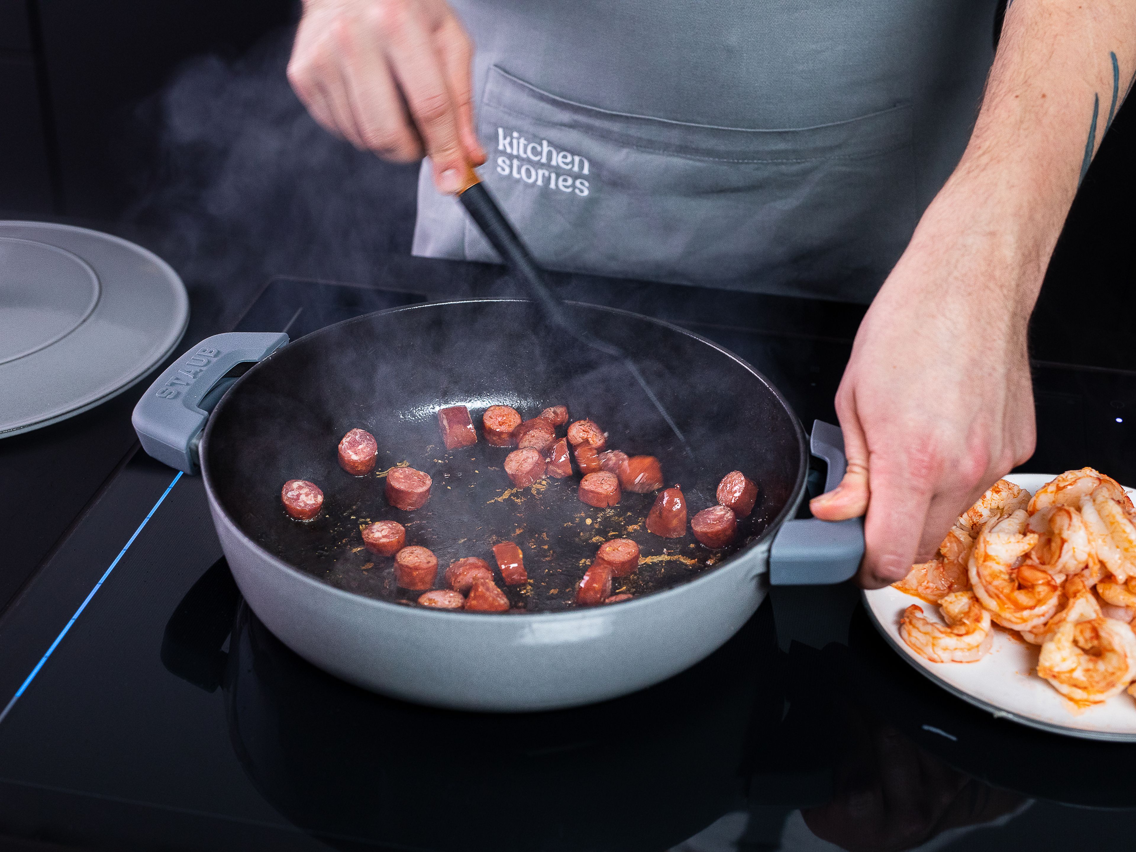 Heat olive oil in a frying pan and fry shrimps for approx 1 min. on either side . Remove from the pan and set aside. Add sliced sausage and fry until golden brown.