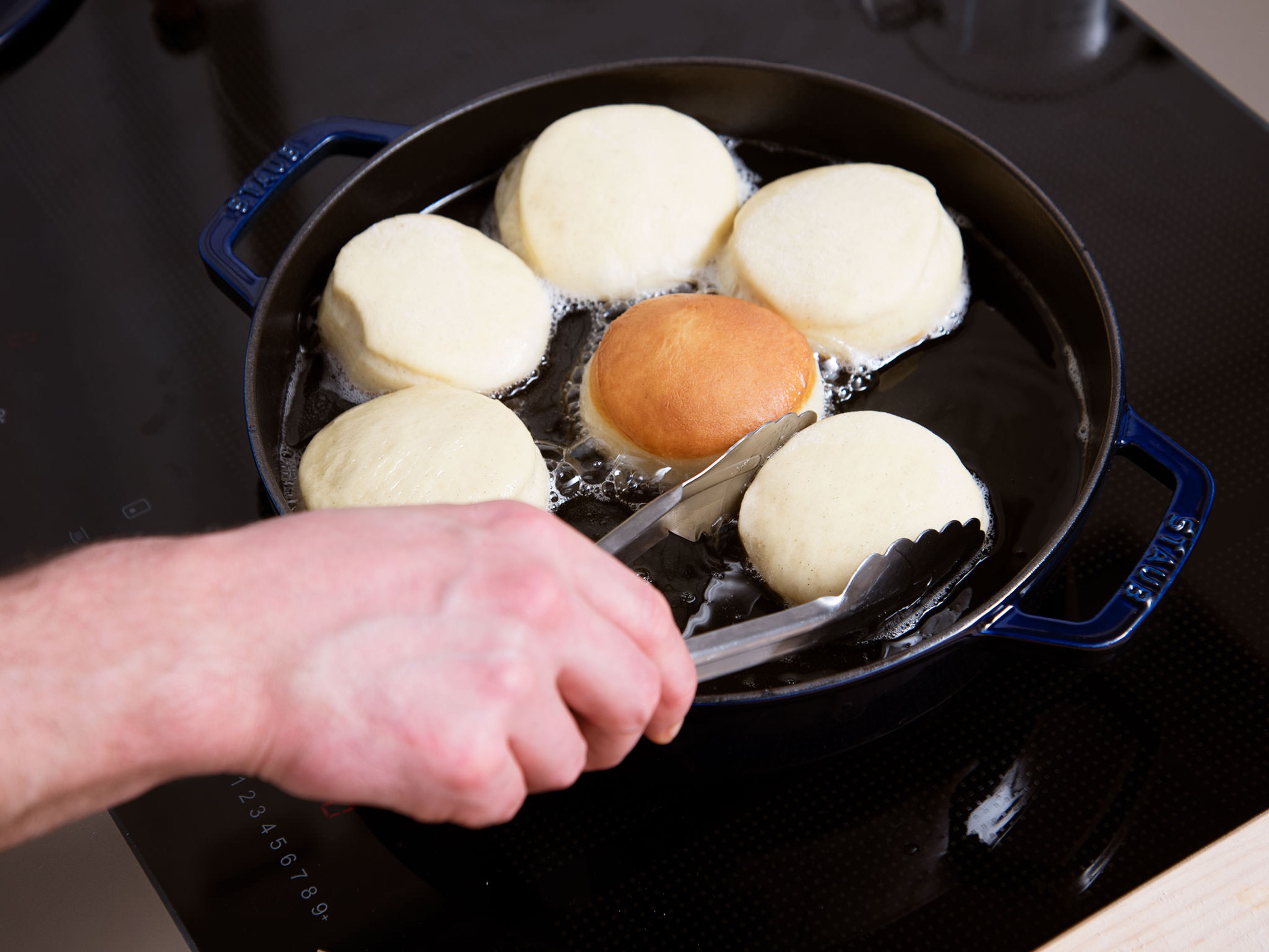 Add oil to a pot and heat until it reaches 170°C/340°F. Carefully add dough circles one by one, then close lid and let fry for approx. 2 – 3 min. Flip carefully and let fry on the other side for approx 2 – 3 min. more. Remove doughnuts from pot and drain on a paper towel-lined plate.
