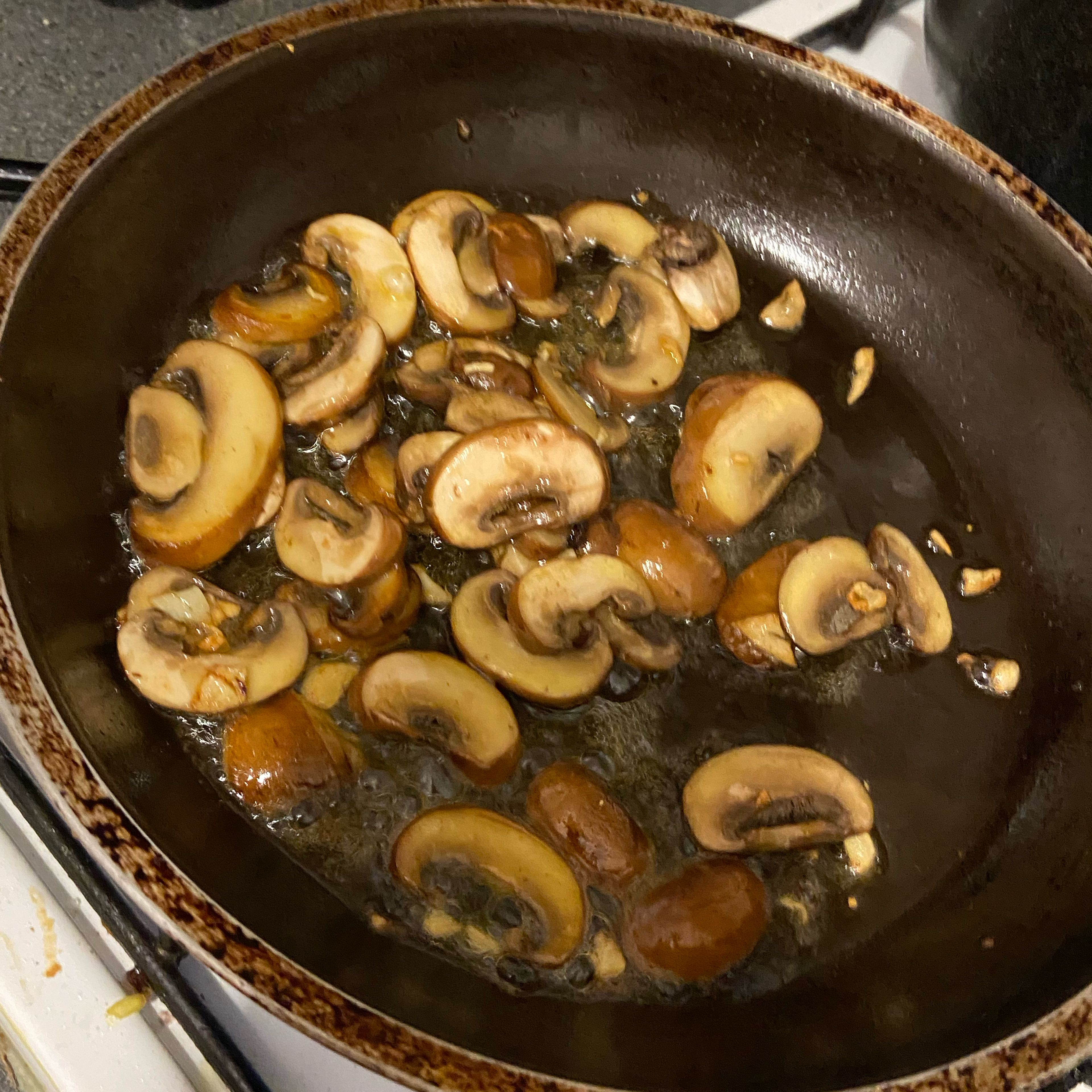Fry the mushrooms and garlic until brown while adding a pinch of salt and pepper.