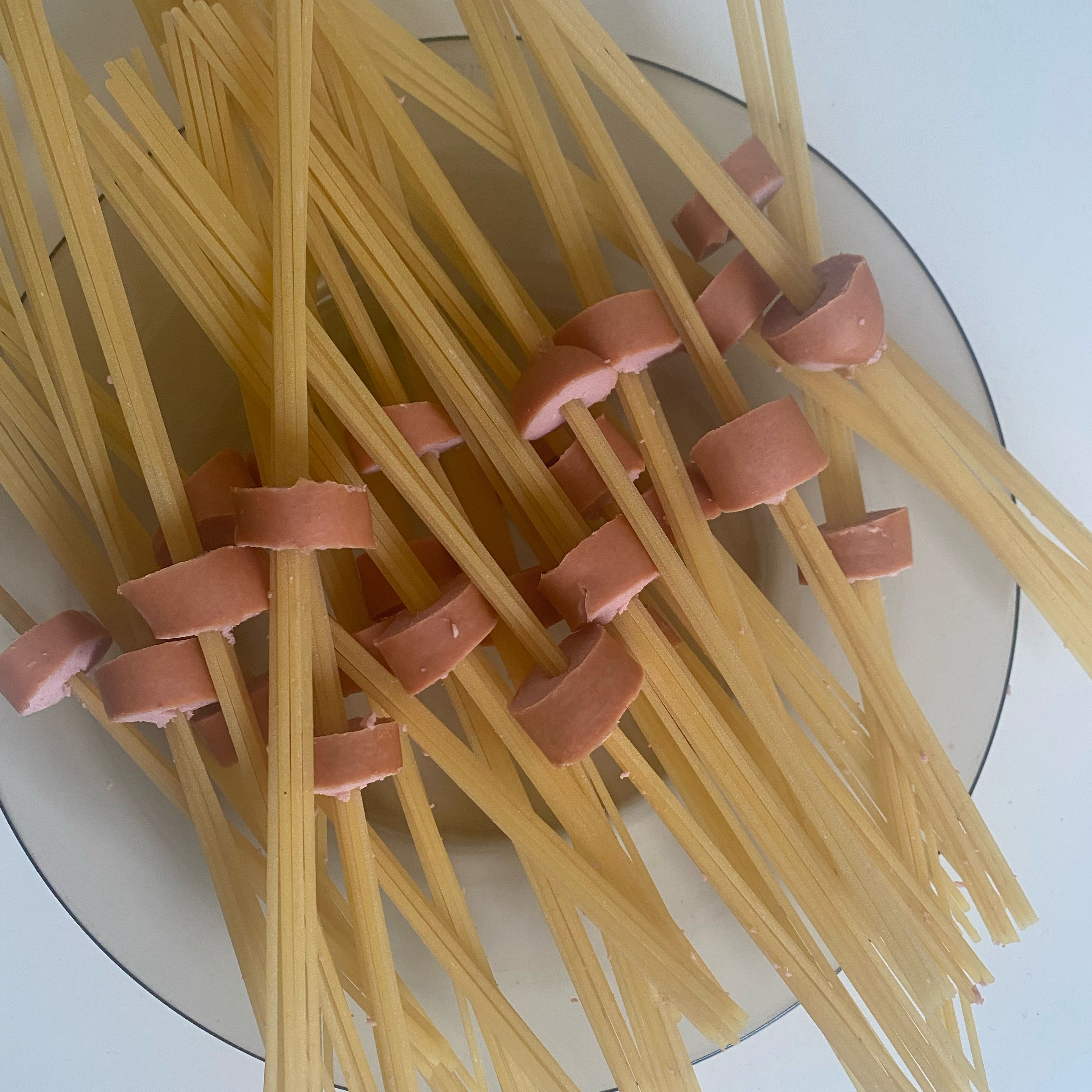 Frankfurter in cm dicke Stücke schneiden und pro Stück ca. 5-8 Spaghetti durchstecken. Wenn in jedem Frankfurter-Stück Spaghetti durchgesteckt sind, Wasser aufstellen um Frankfurter-Spaghetti in Salzwasser zu kochen. Restliche Nudeln einfach mitkochen.