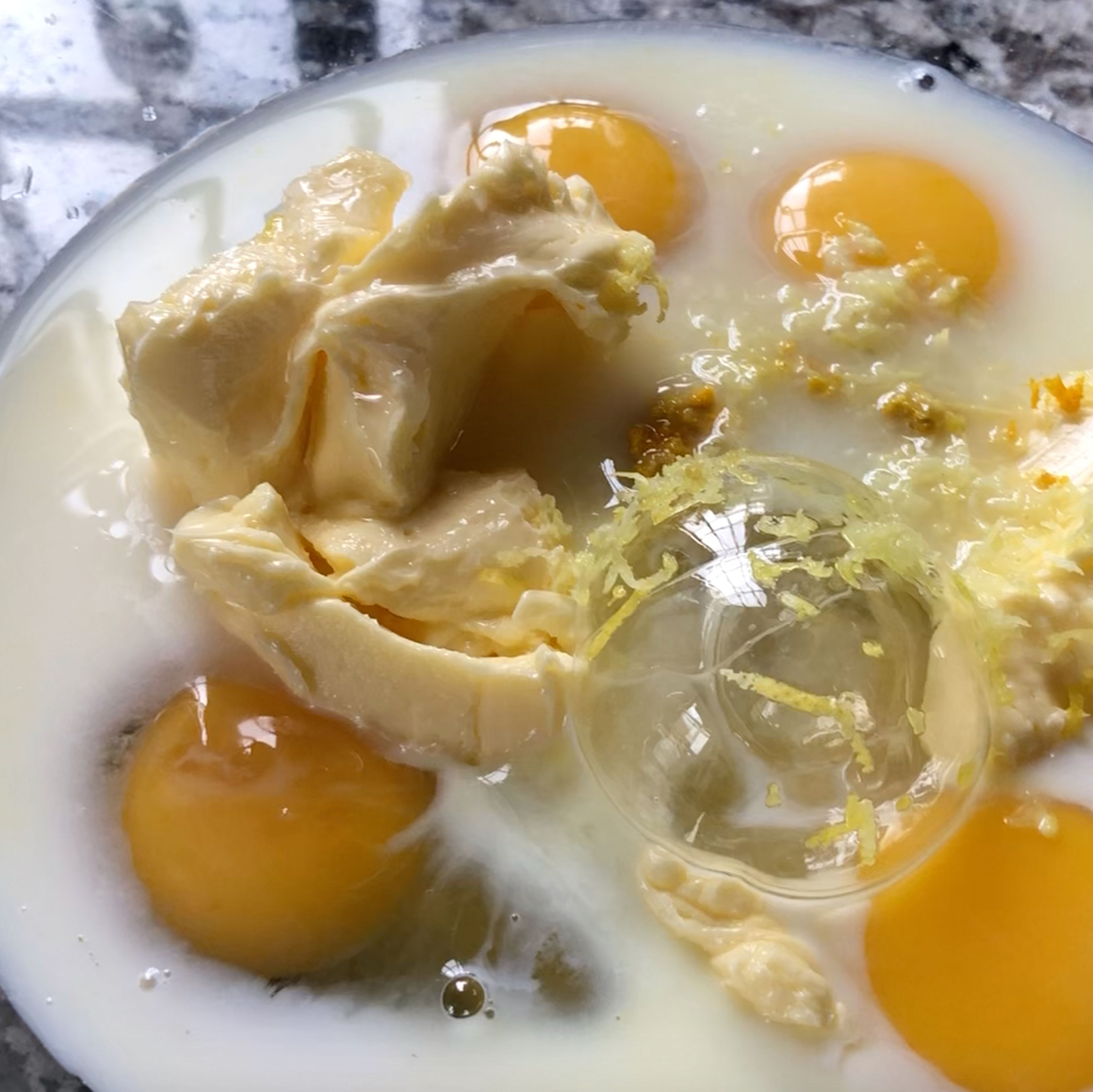 Meanwhile, put the wet ingredients in another bowl. Sugar, eggs, milk, room temperature butter, lemon zest, orange blossom water and vainilla essence.
