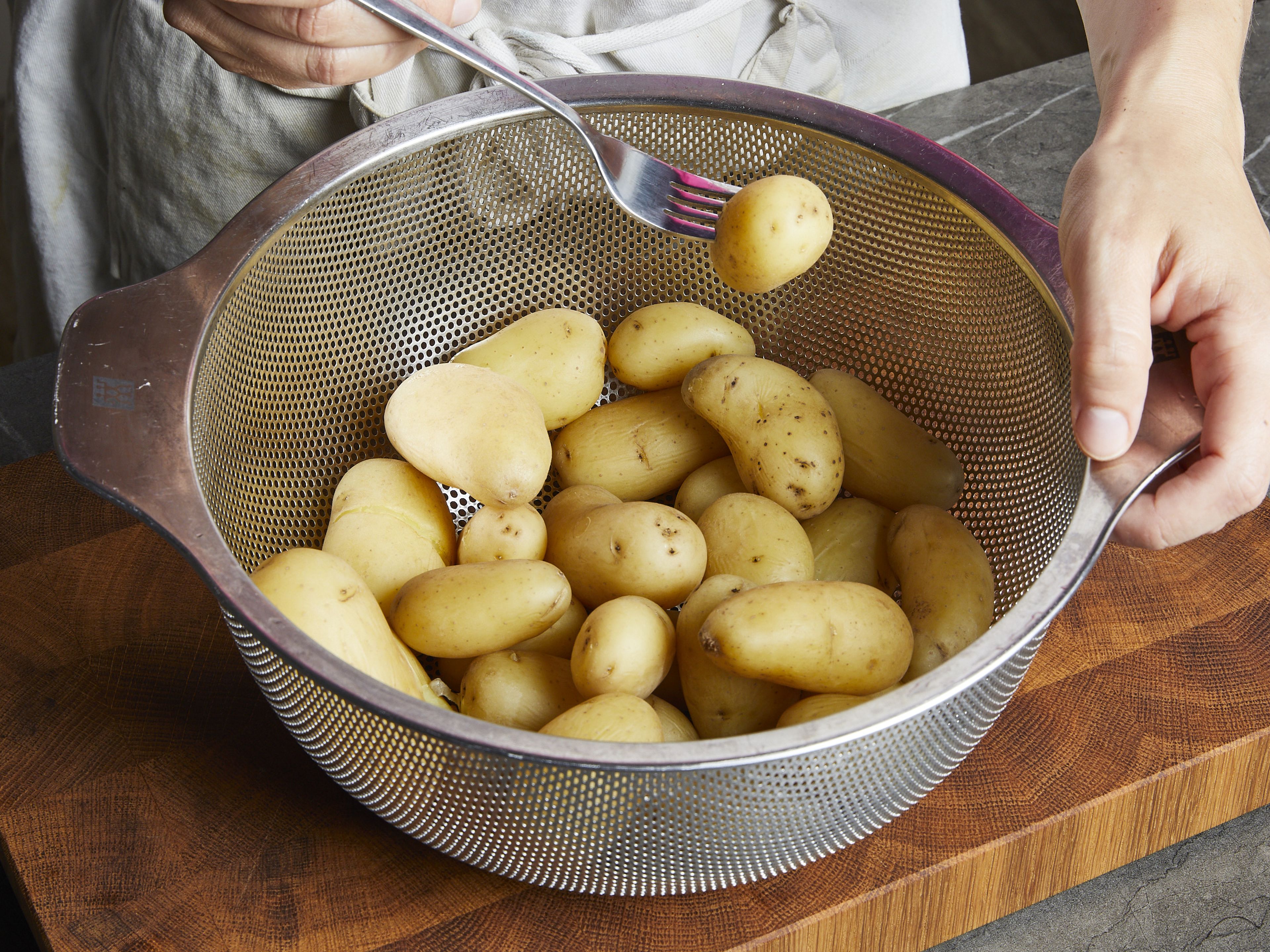 In einem großen Topf Wasser zum Kochen bringen, gut salzen und die Kartoffeln darin ca. 15 Min. kochen. Wenn die Kartoffeln größer sind, lass sie etwas länger kochen, bis sie gabelweich sind. Abgießen und beiseitestellen, um sie etwas abzukühlen.
