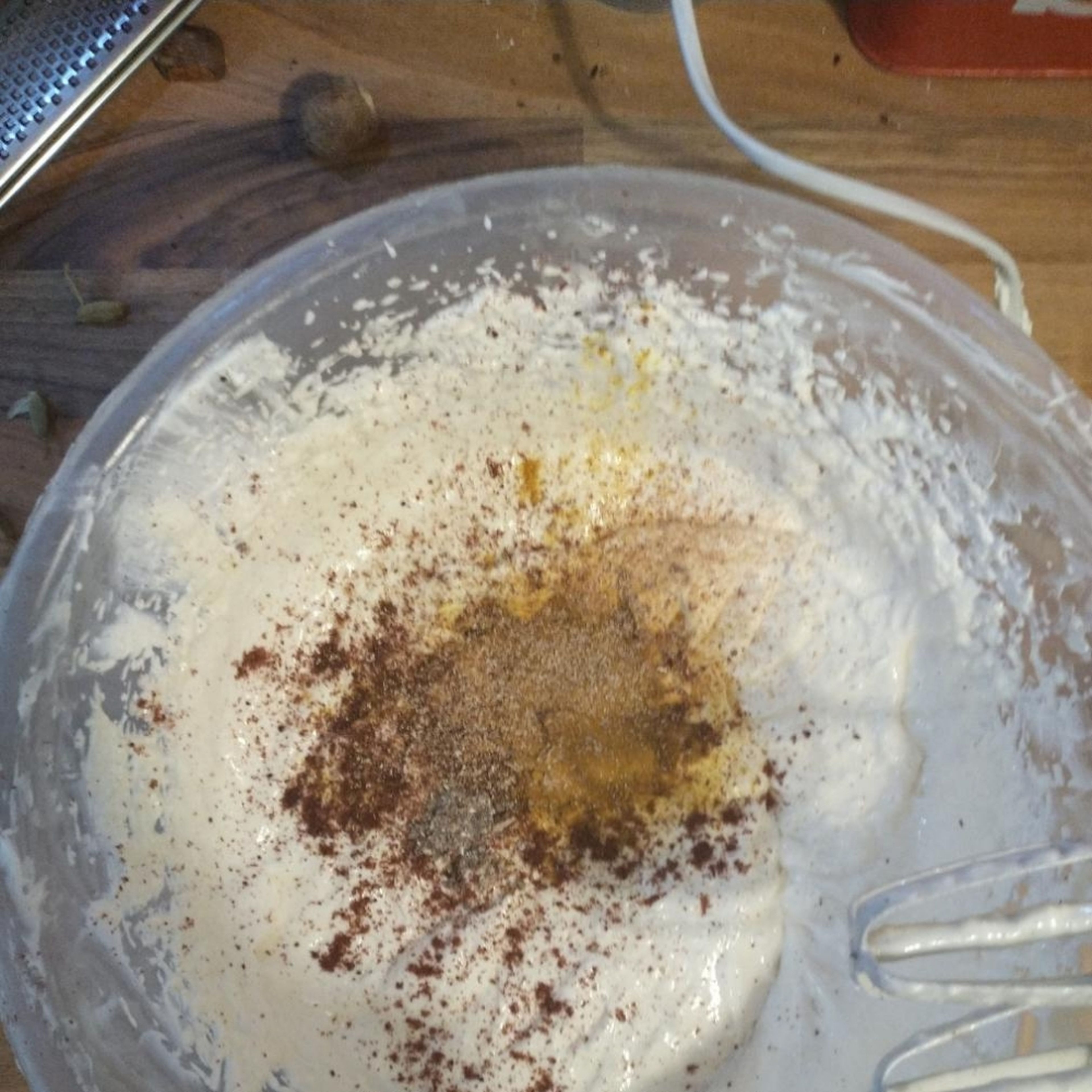 Add the sugar, little by little, until fully incorporated and lump-free. Crack open the cardamom pods and grind the seeds in a pestle and mortar. Add it to the mixture, along with the nutmeg, tumeric and a tsp of the sumac, as well as the salt. Whisk for a further 2 minutes.