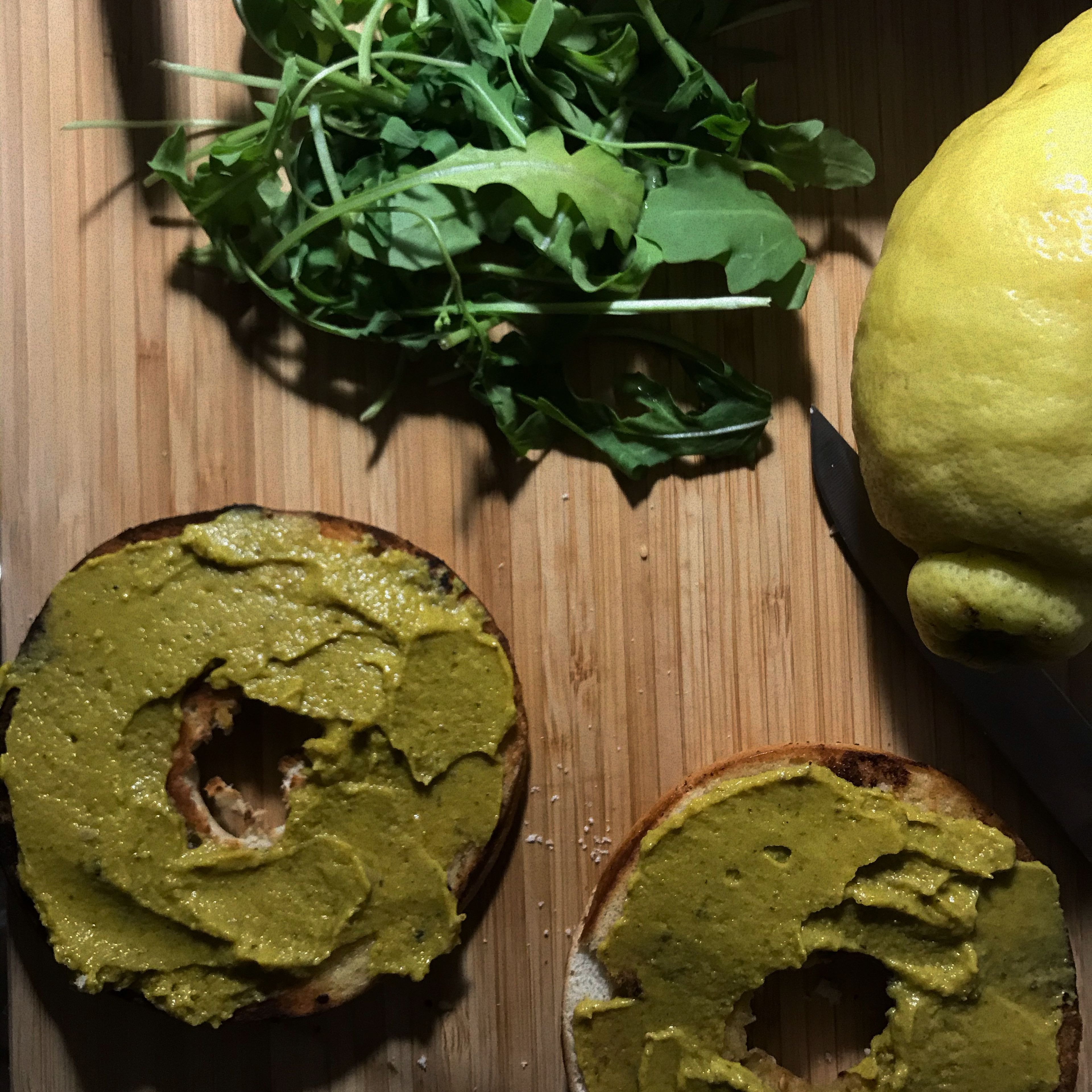 Hummus mit Garam Masala und Zitrone vermischen. Anschließend die Innenseiten der Bagels mit der Hummuscreme bestreichen.