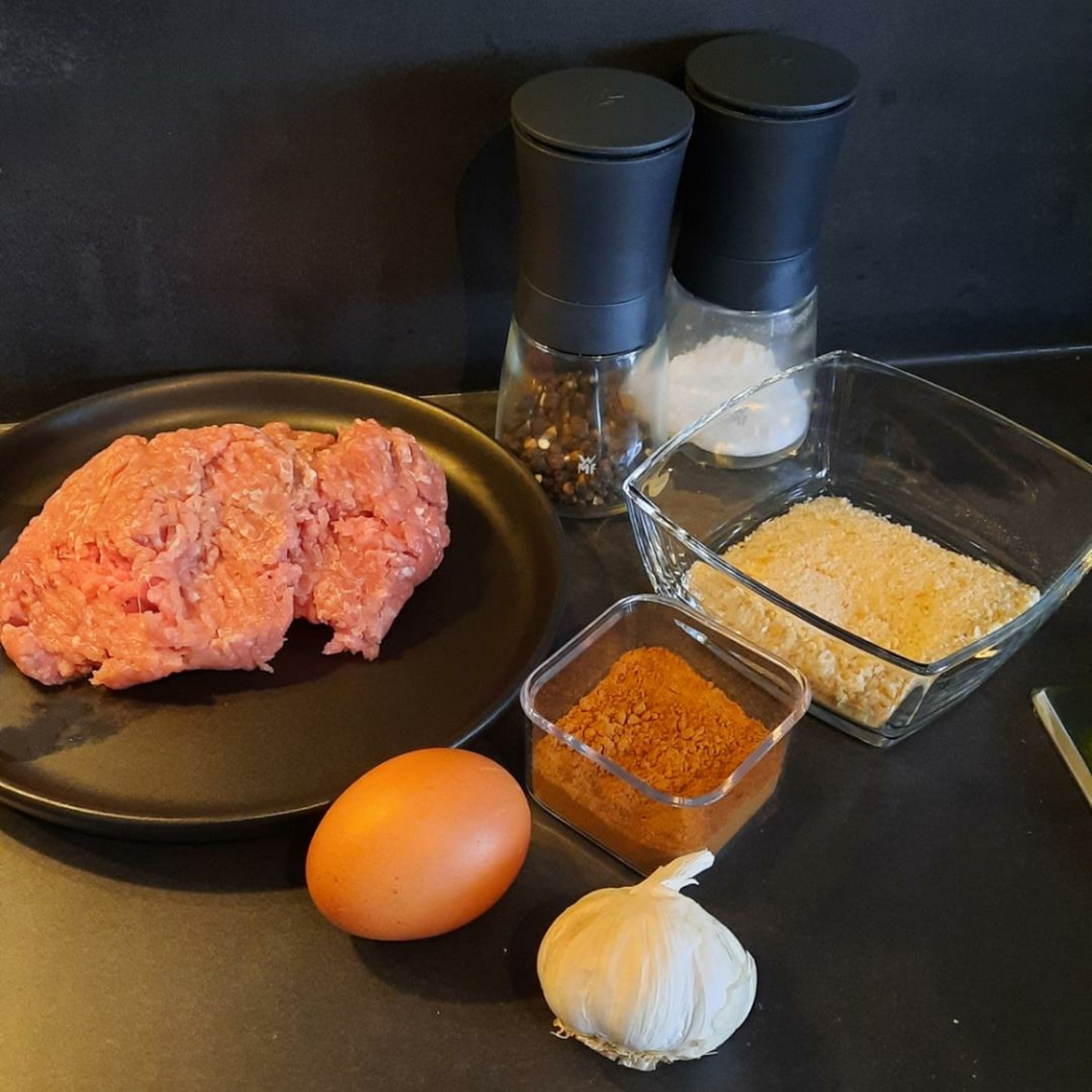 For the meatballs, combine ground beef, egg, breadcrumbs, nutmeg, and cinnamon in a bowl. Press garlic into the mixture and season with salt and pepper.