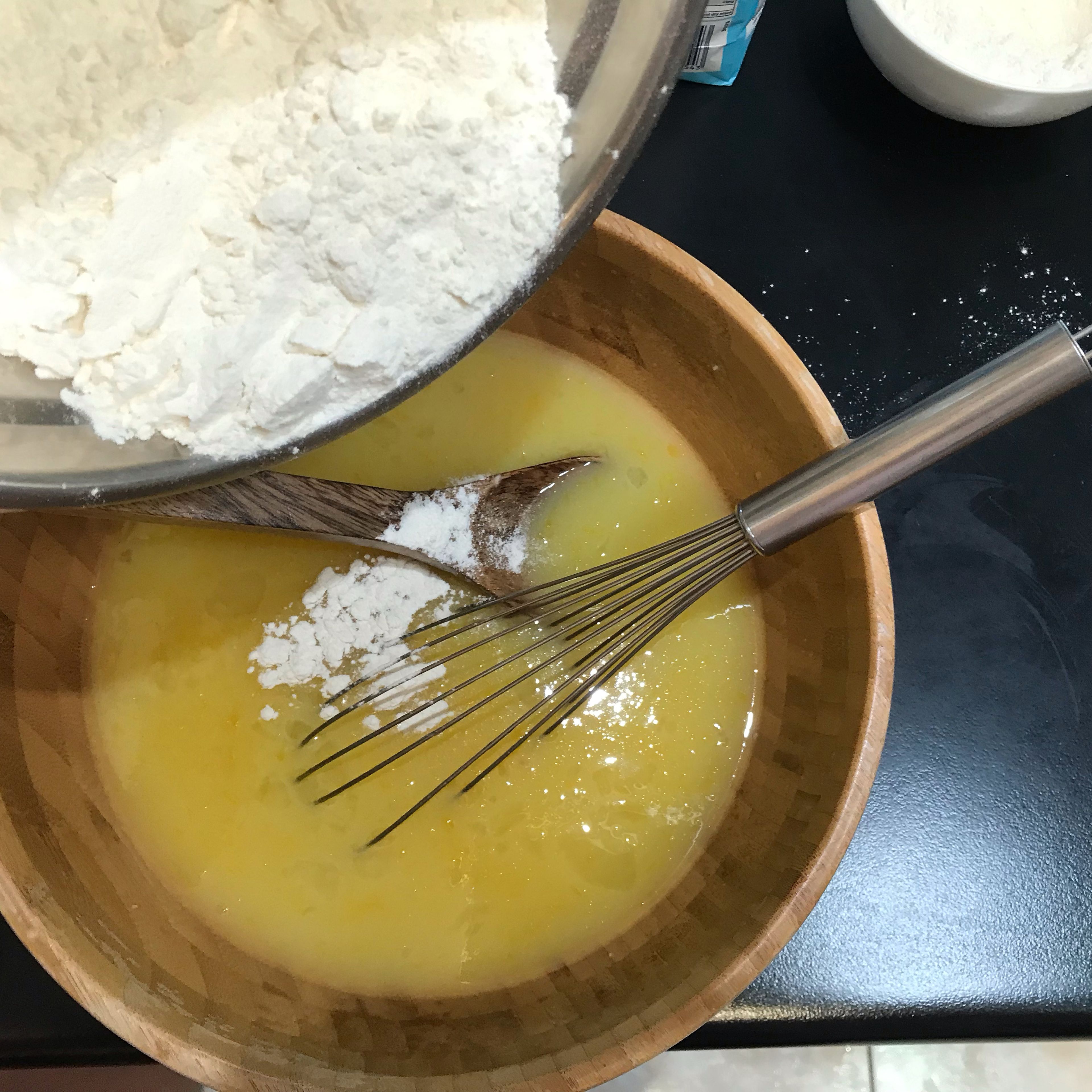 Sift flours together into a separate bowl. Whisk sifted flours, extract, eggs and purple food coloring into the white chocolate mixture. (The purple food coloring will help to offset the yellow color in the batter.)