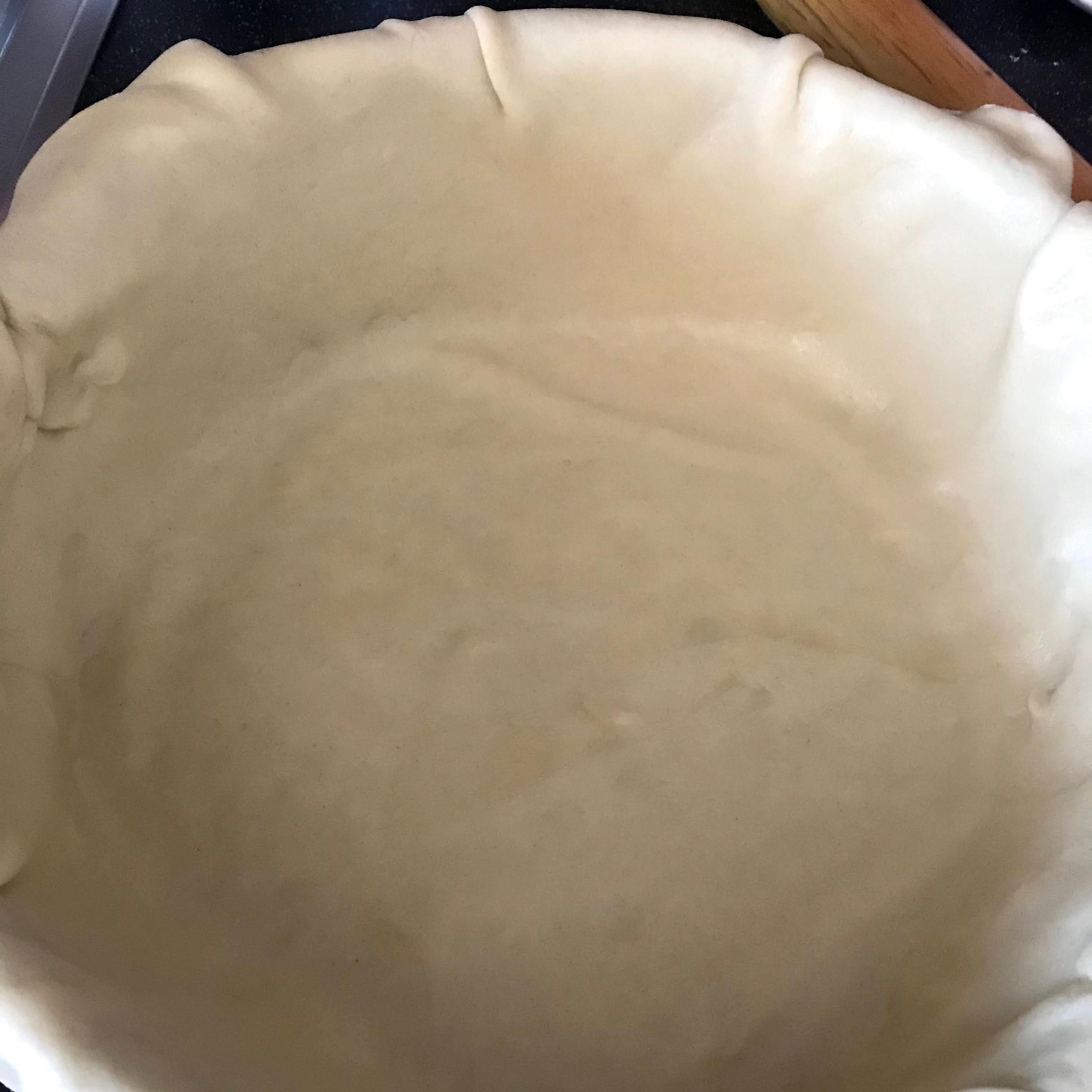 Sprinkle flour on the work surface and roll out the bottom pie crust into a circle. Wrap it around the rolling pin,then transfer it to the pie dish and add the apple mixture.