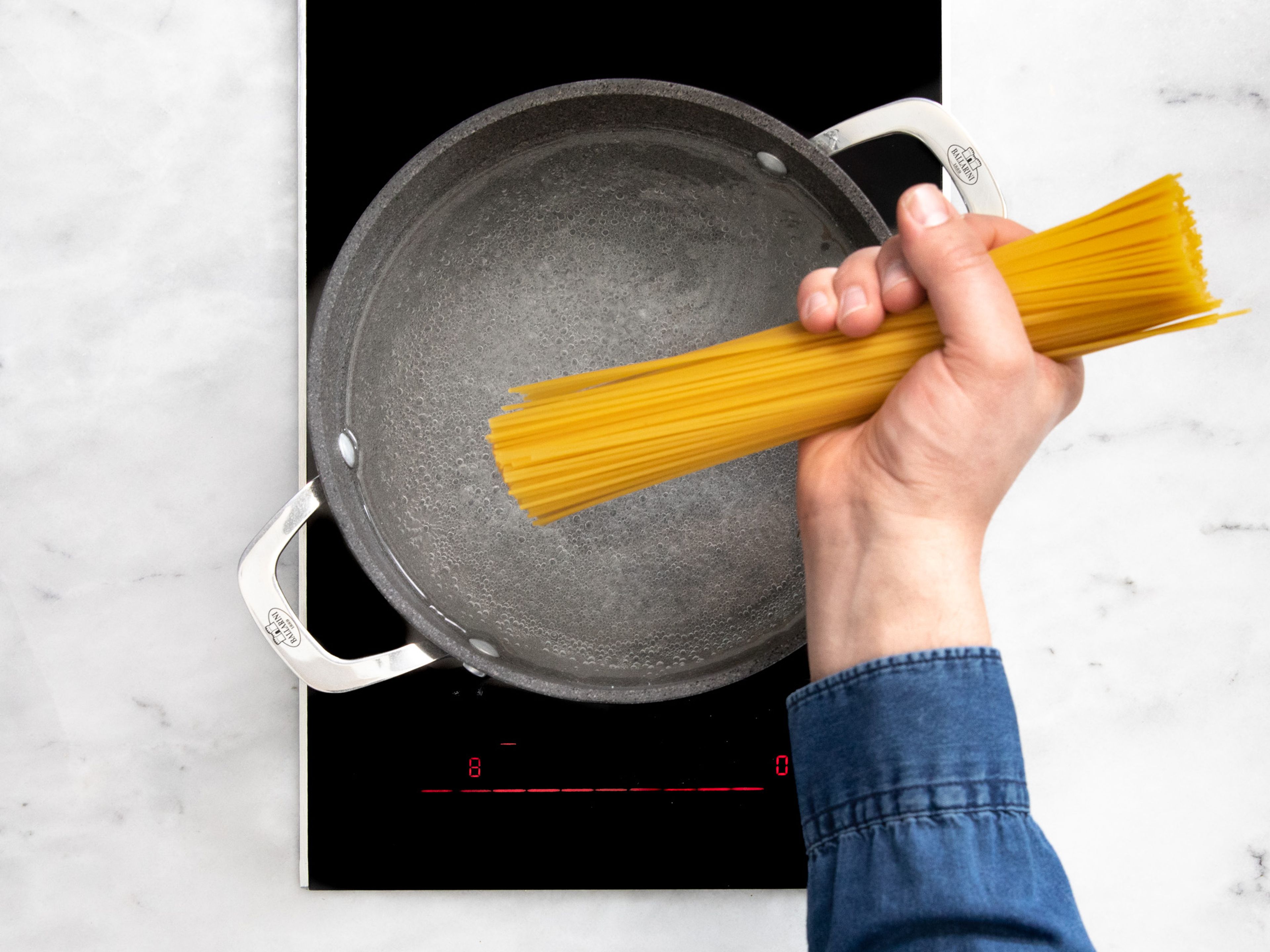 Einen Topf mit Wasser auf mittlerer Stufe erhitzen. Sobald das Wasser kocht, Salz dazugeben und Spaghetti nach Packungsanweisung kochen.