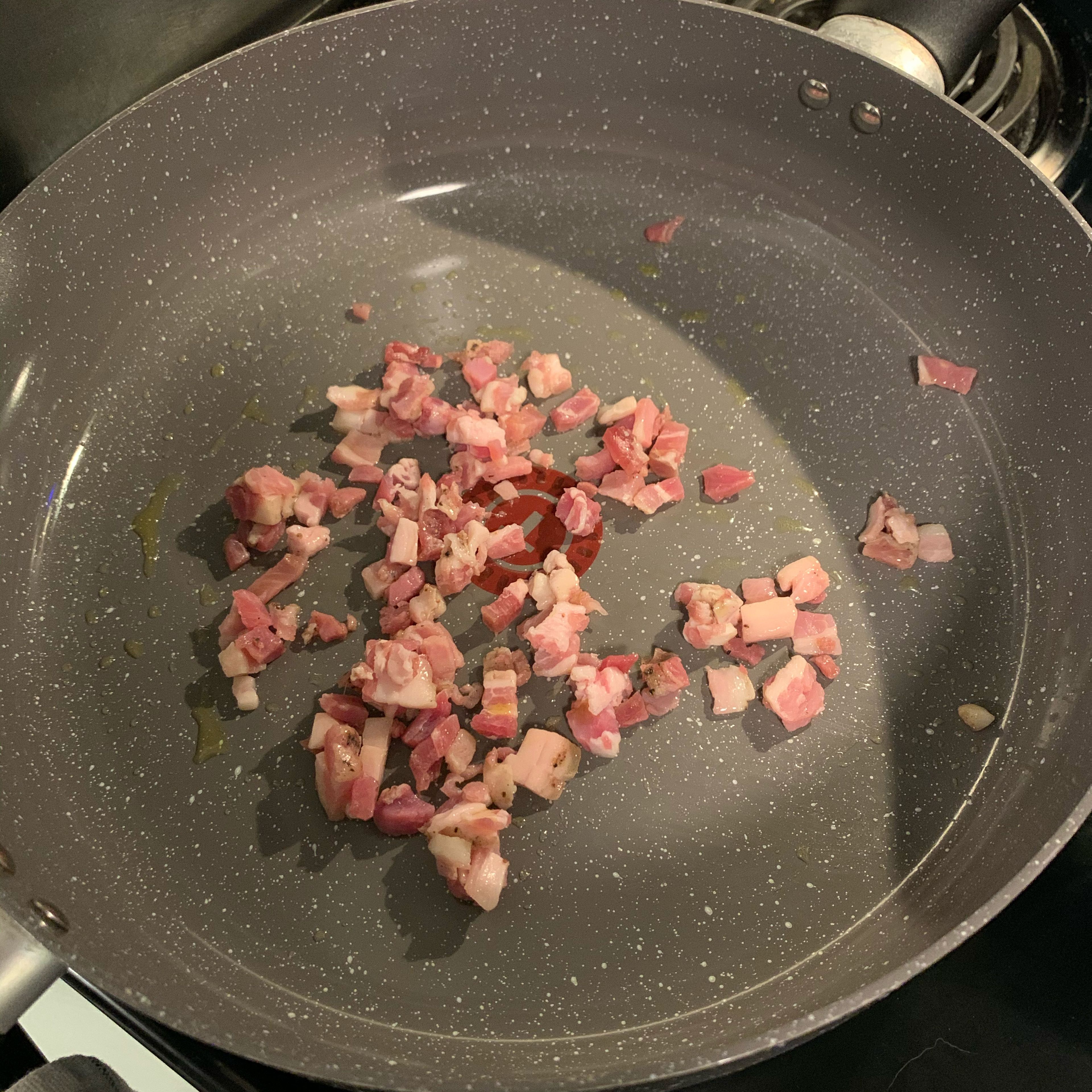 Add pancetta and a little olive oil to pan over medium heat. Cook until brown and crispy. You’ll want to cover the pan halfway with the lid to stop oils from splashing everywhere. My deli had a 2 serving pack available.