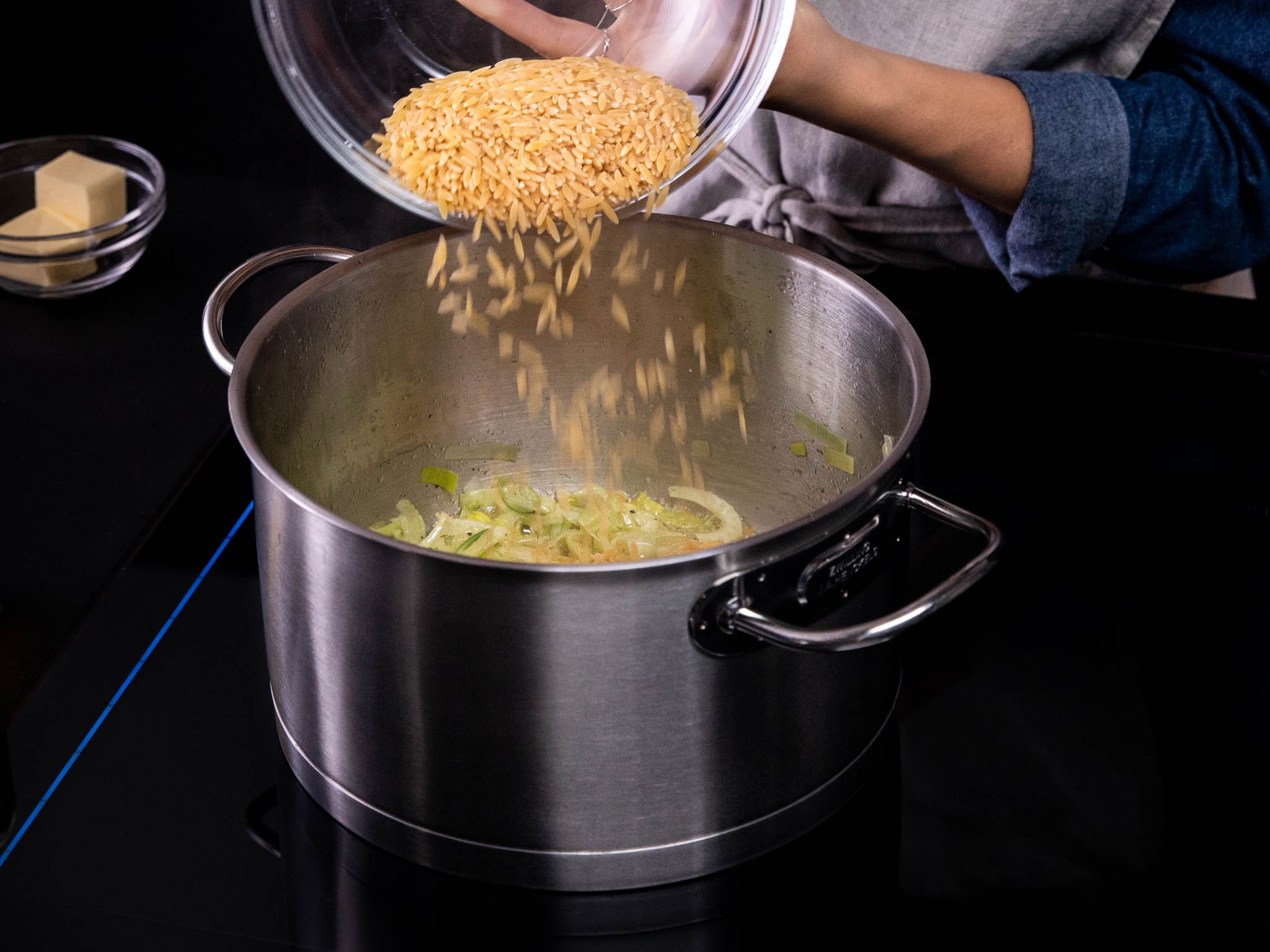 In a pot over medium heat, add half the butter and a bit of olive oil. Once the butter is melted, add leek and fennel. Season with salt and pepper and sauté for approx. 8 min., or until tender and translucent. Then add orzo, stirring to combine, and let cook for approx. 3 min.