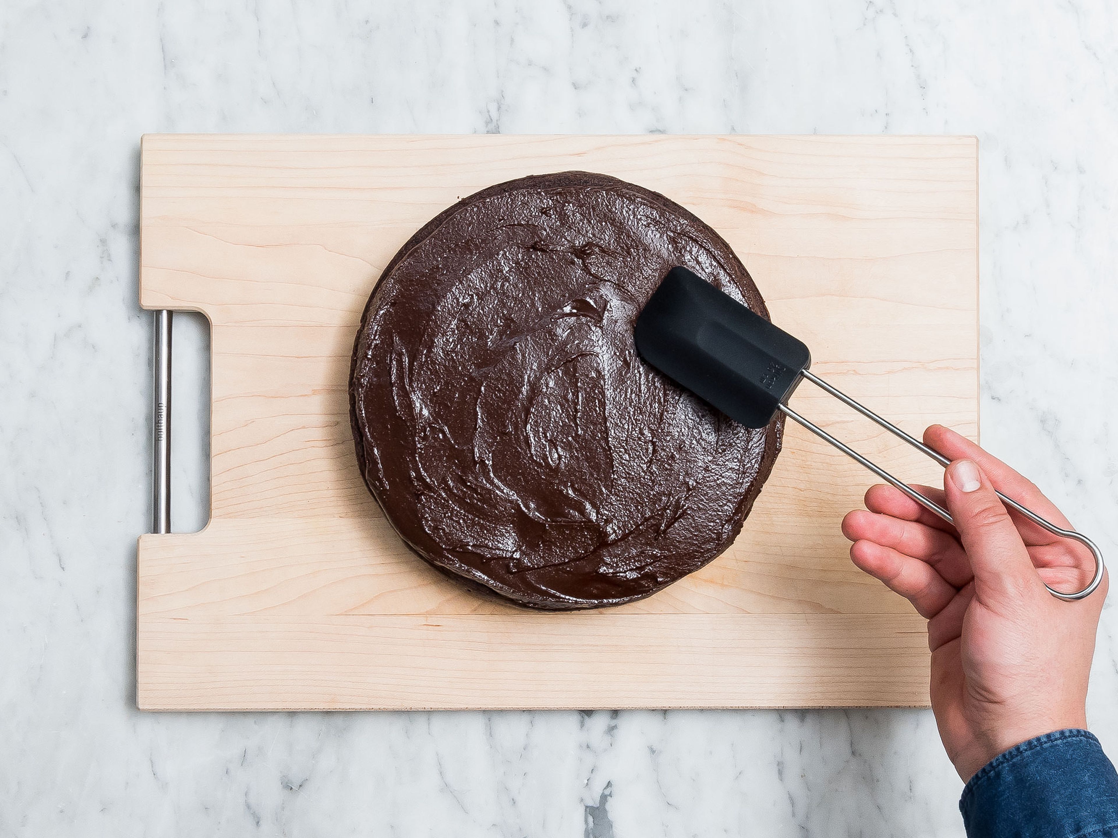 Remove the cake from the baking pan and halve to get two cake layers. Transfer one cake layer onto a large plate and spread one third of the chocolate cream on it. Add the second cake layer on top and spread the remaining chocolate cream on top and if desired also around the sides. Enjoy!