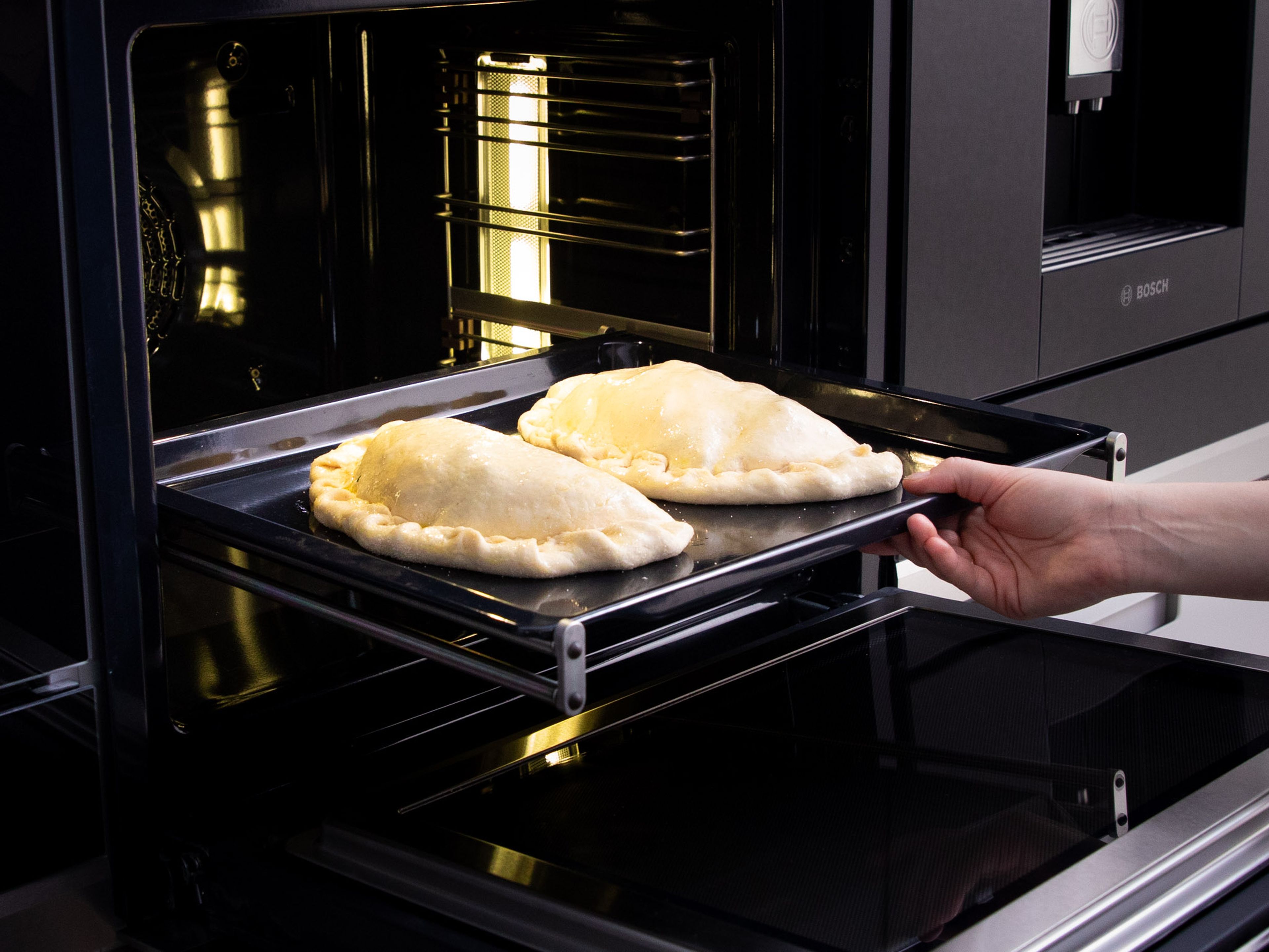 Transfer calzone to a baking sheet and brush with olive oil. Bake at 220°C/430°F for approx. 10 min.
