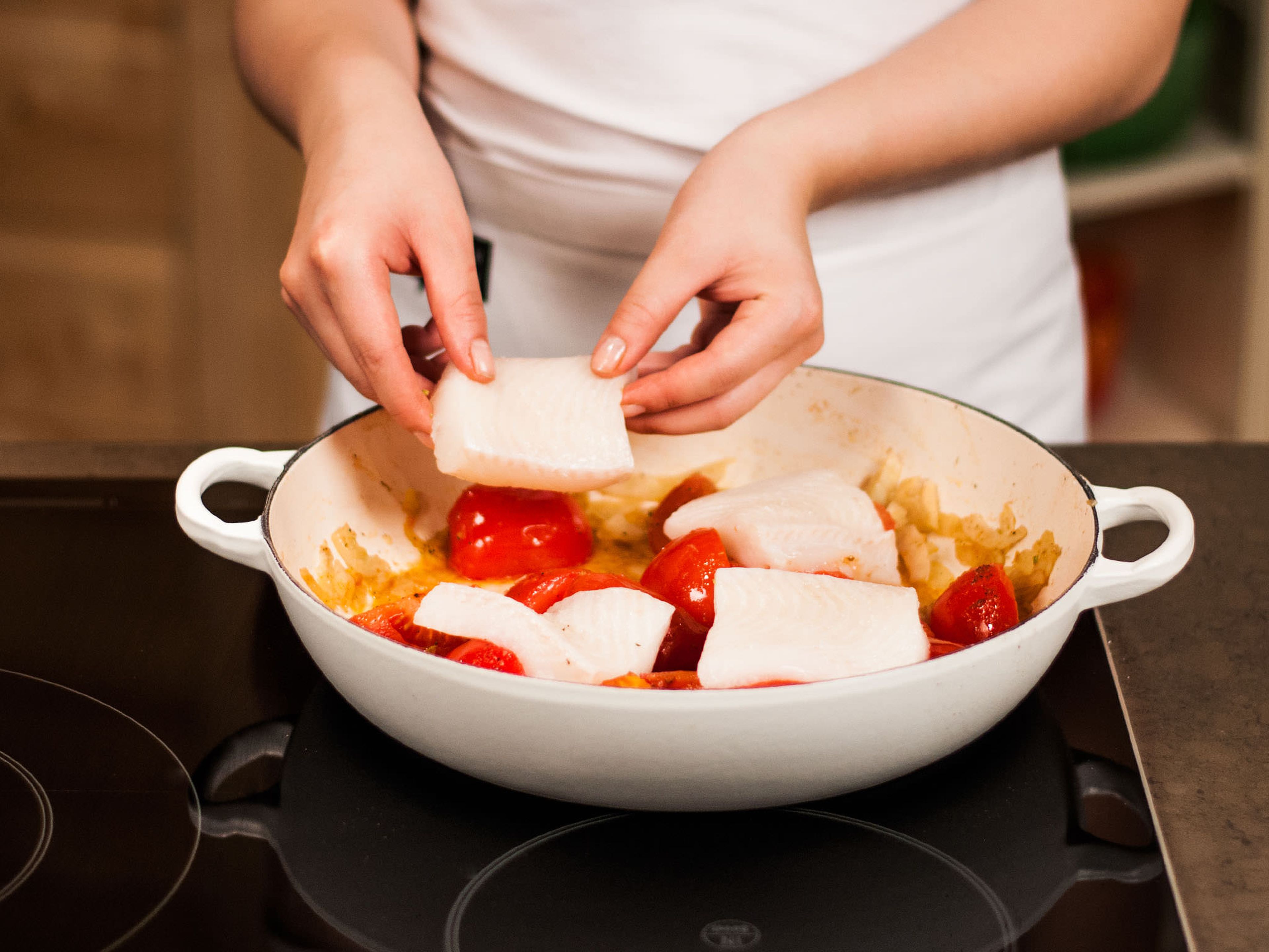 Seelachs auf das Tomatenbett legen. Jeweils eine Zitronenscheibe auf den Filets platzieren, salzen, pfeffern und bei geschlossenem Deckel ca. 8 Min. bei mittlerer Hitze garen, bis der Fisch glasig ist. Auf Couscous anrichten.